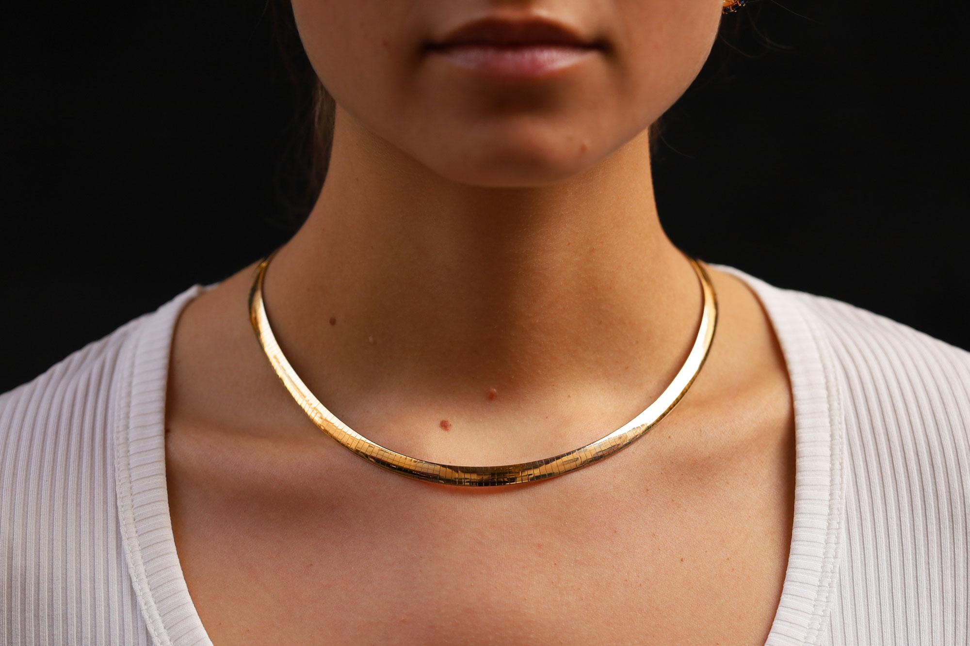 This vintage Omega necklace is a classy essential to all jewelry collections. Sustainably crafted with 1nearly one ounce of 14k gold, this, sleek, wide necklace features a reversible design with decadent yellow gold on one side, and flashy white