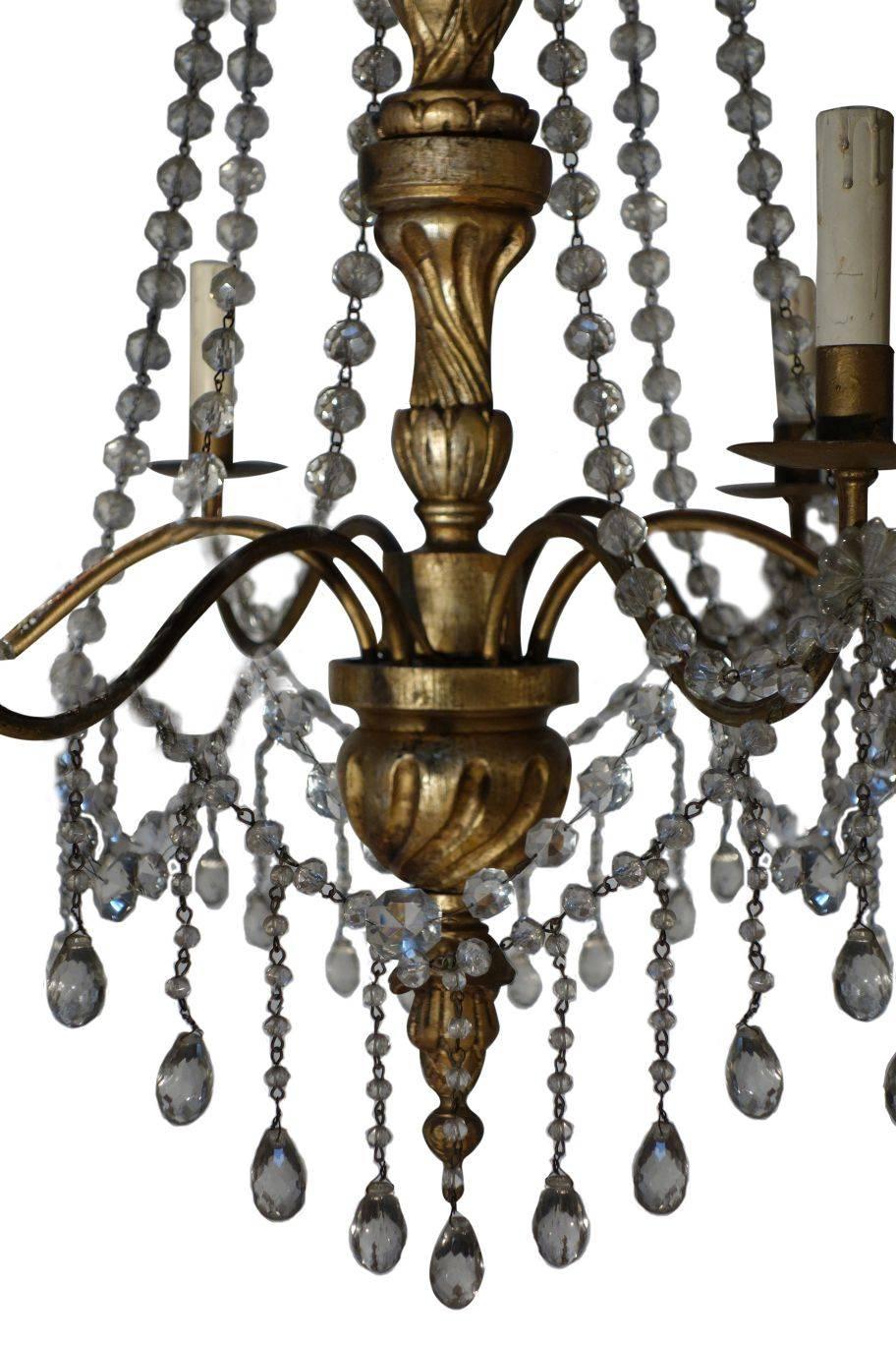 Vintage Italian Gold Painted Genova Style Chandelier with Cut Glass Drops and Strands:
Lovely Italian vintage 6-arm chandelier featuring a balanced presentation of gold painted wood, cut glass and burnished wrought iron. The upper iron tiers and