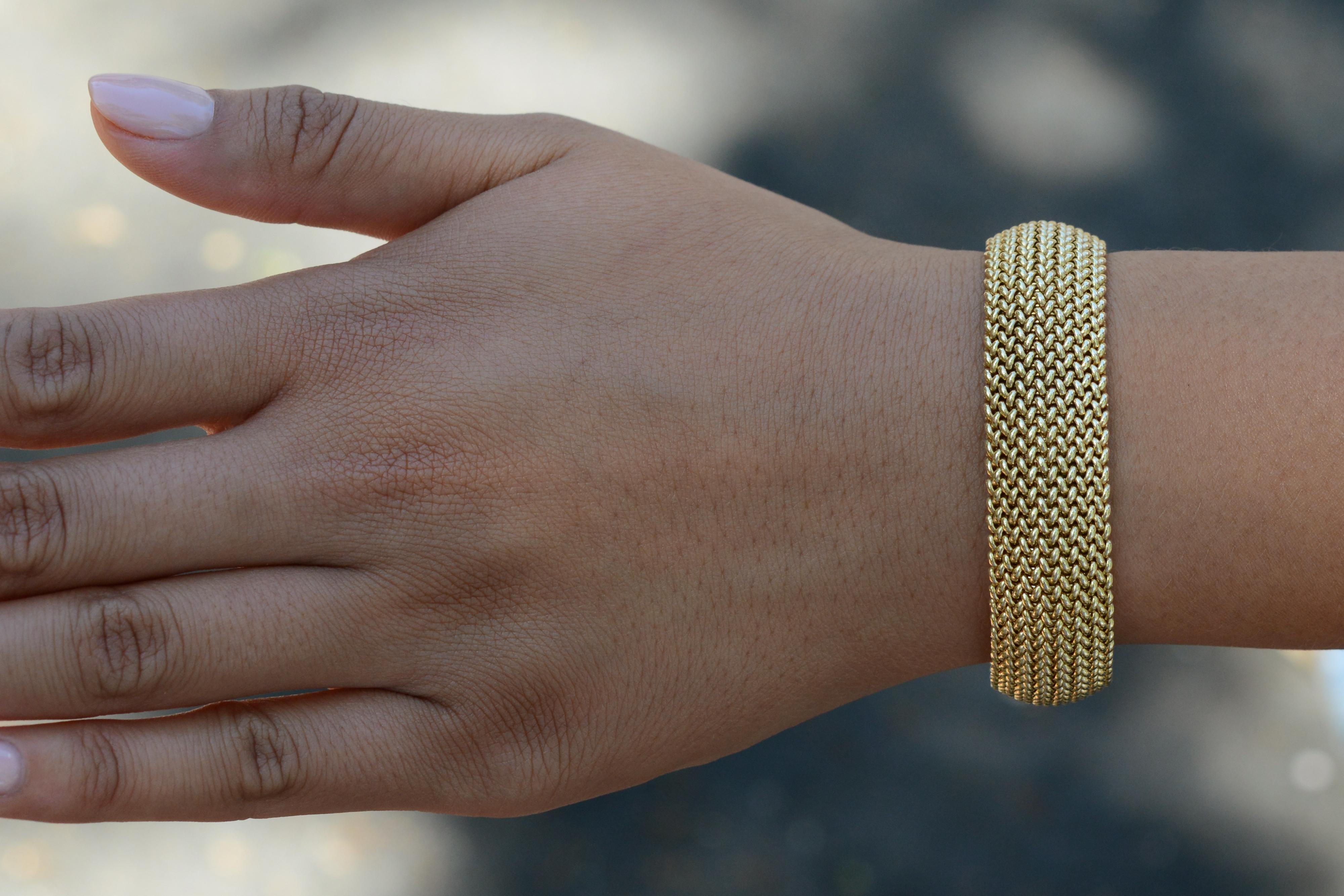 This authentic 1970s vintage, wide woven bracelet is a luxurious addition to any jewelry collection. Crafted with solid 14 karat yellow gold and a classic Riso (rice) Italian design, this substantial piece provides excellent coverage and boasts an