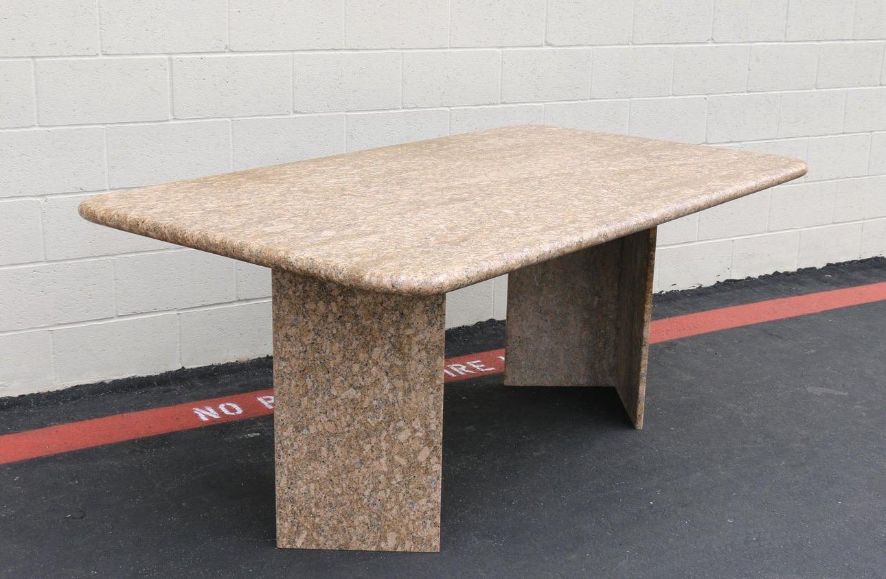 Spectacular Italian dining table made of granite stone. From the 1980’s.  It has two granite stone pedestal based one of them has a small chip, other than that the table remains in good shape. Wonderful table very strong and sturdy. Beautiful colors.