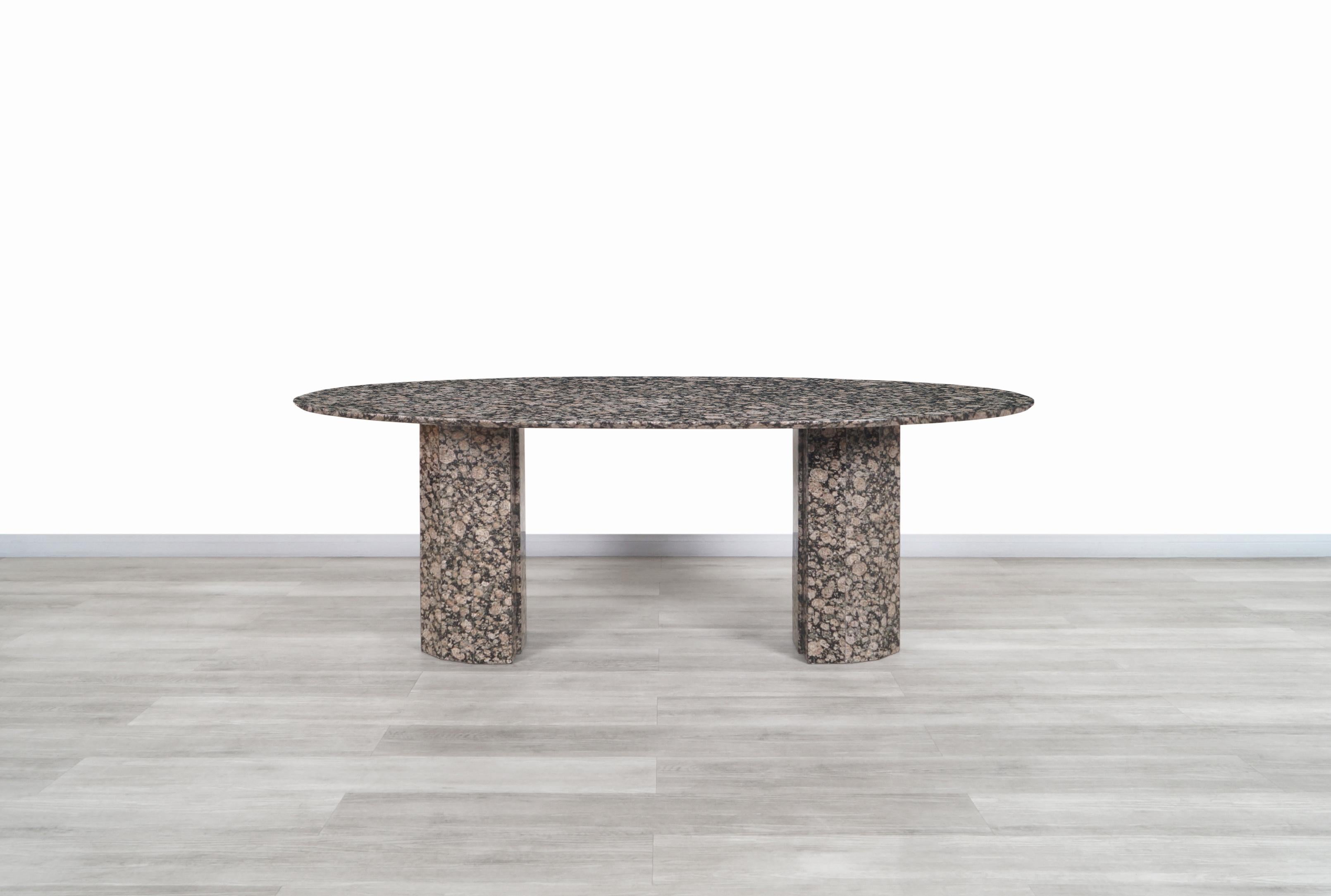 Stunning vintage Italian granite oval dining table designed and manufactured in Italy, circa 1980s. This table is built from granite stone, where the minerals that compose this stone shine through the entire table, giving it a fantastic contrast of