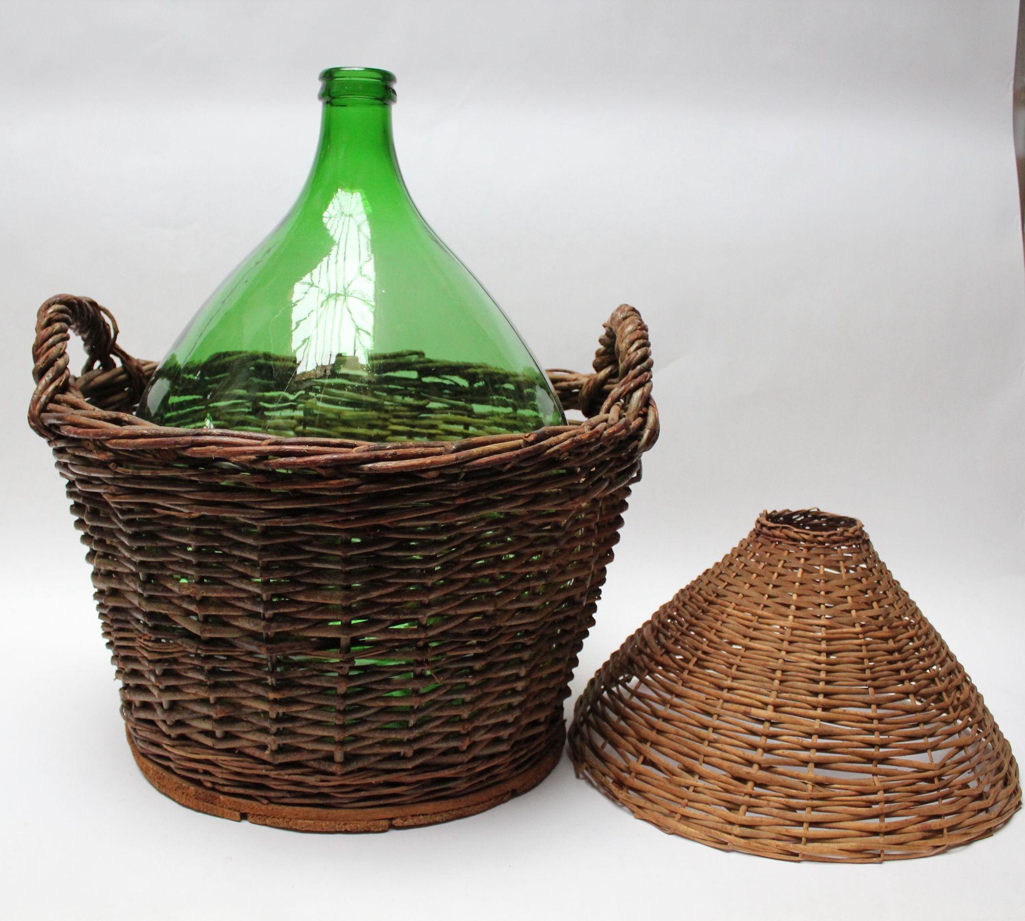 Large green glass 54-liter demijohn/carboy with wicker carrier originally used for transporting wine produced by Villani (ca. mid-20th Century, Italy).
Few long scratches to glass along with general, age-commensurate wear. Basket is structurally