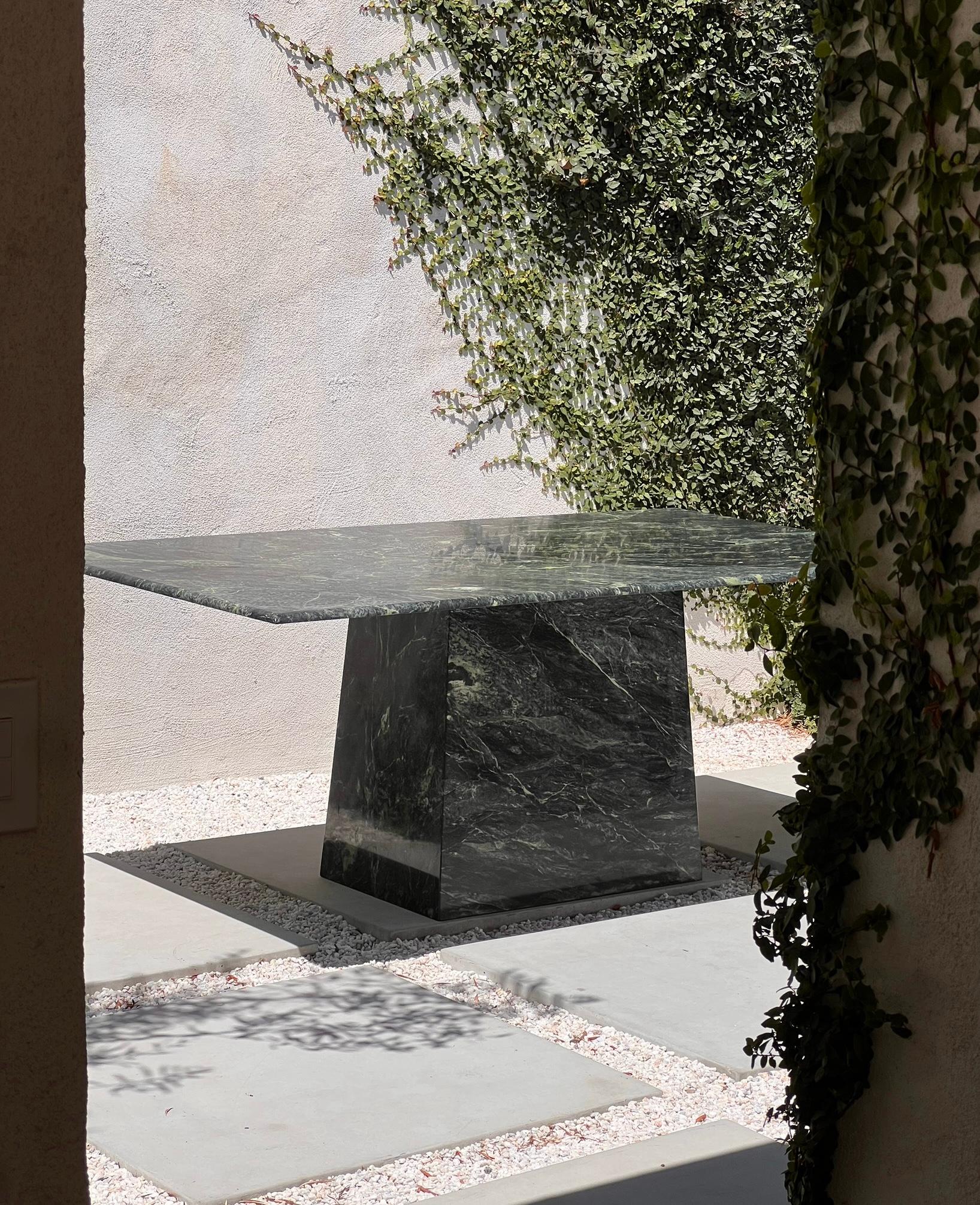 A vintage Italian green marble dining table with trapezoidal base, late 20th century. Tones of chard and pine with a dash of key lime in the marbling make this piece an absolutely extraordinary relic of the latter part of the twentieth century,