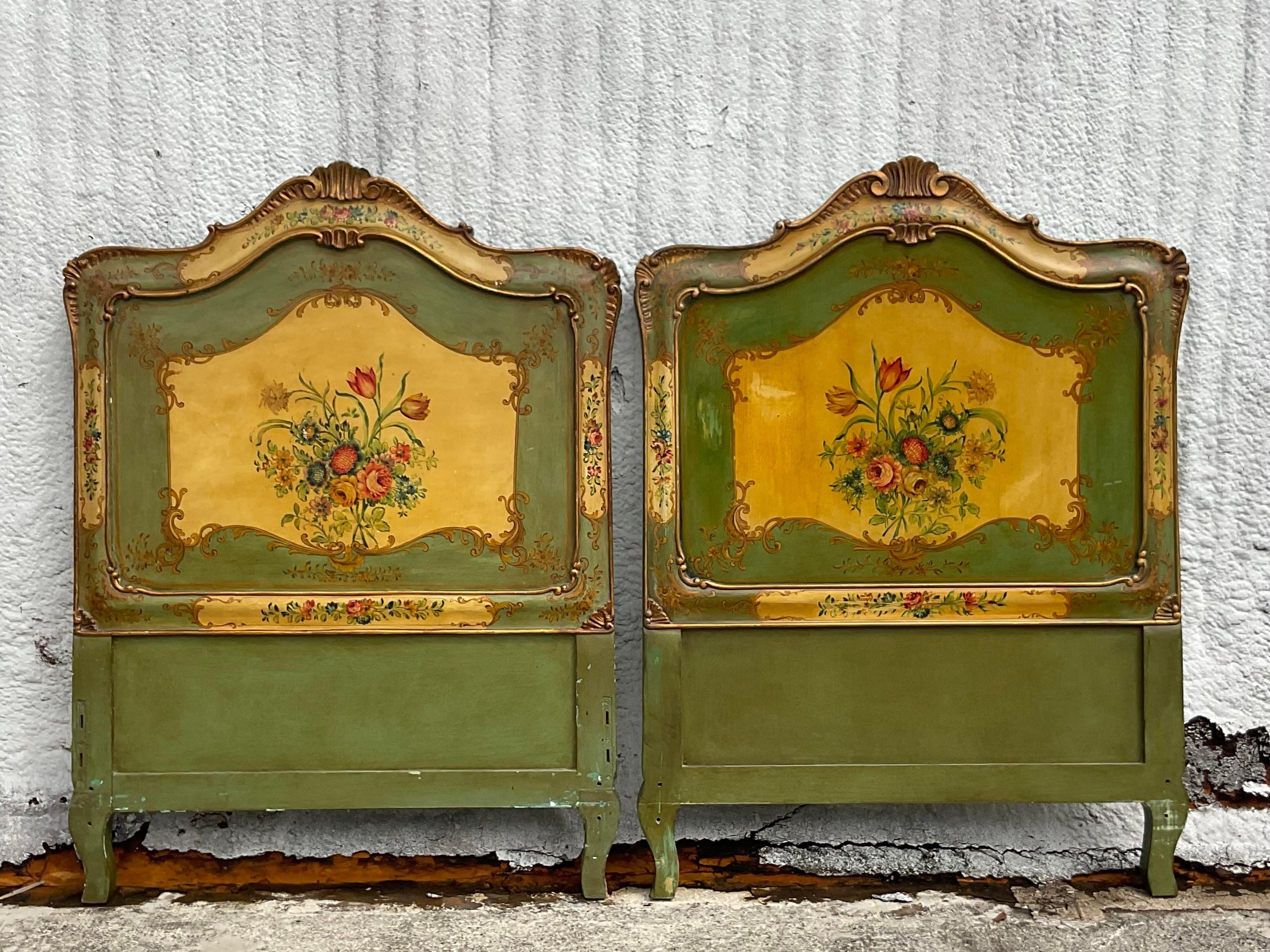 A fabulous pair of vintage Italian twin headboards. Beautiful carved detail with incredible hand painted flora design. A gorgeous all over patina from time. Acquired from a Palm Beach estate.