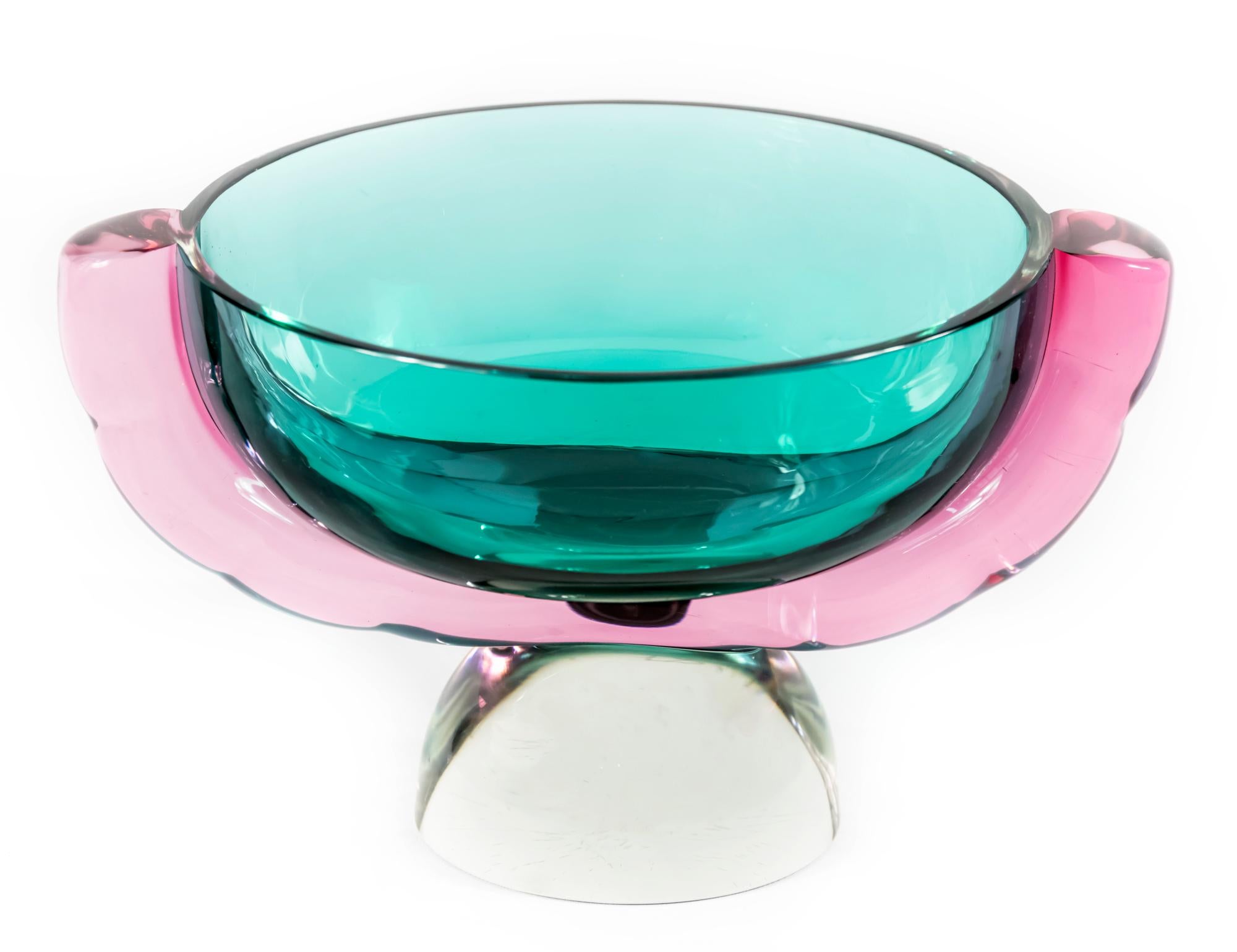 Ce vase en verre de Murano, fabriqué à la main en Italie, a été créé et signé par Marcello Furlan en 1980.
Les couleurs du verre sont le vert émeraude et le violet sur une base en verre transparent. Ce vase est solide et lourd.