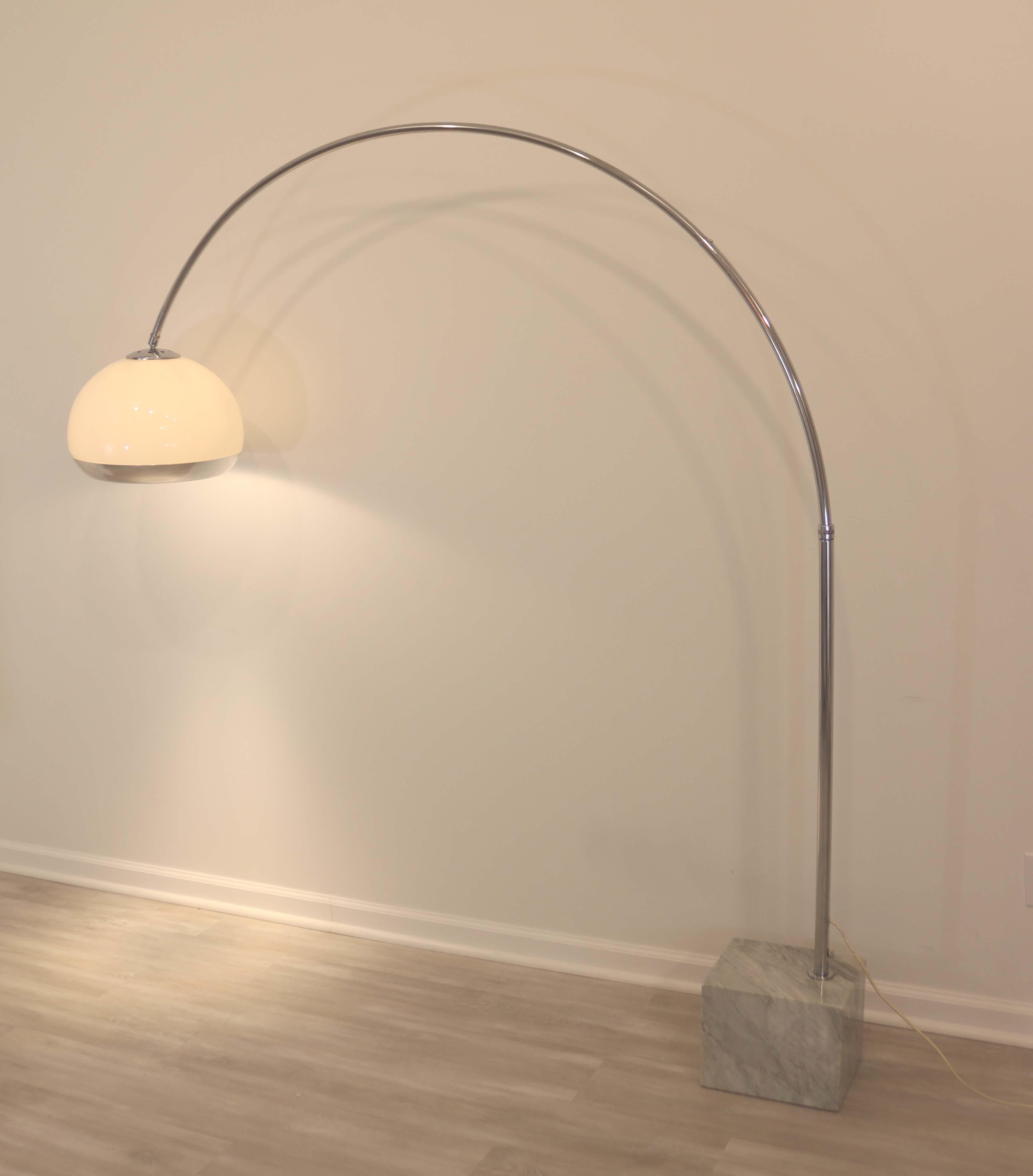This mid century Italian Arc floor lamp designed by Harvey Guzzini for the Laurel Light Company circa the 1970's features a tubular chrome arc, an acrylic, aluminum globe shade and counter weighted with a Carrara Marble base. The shade requires 2