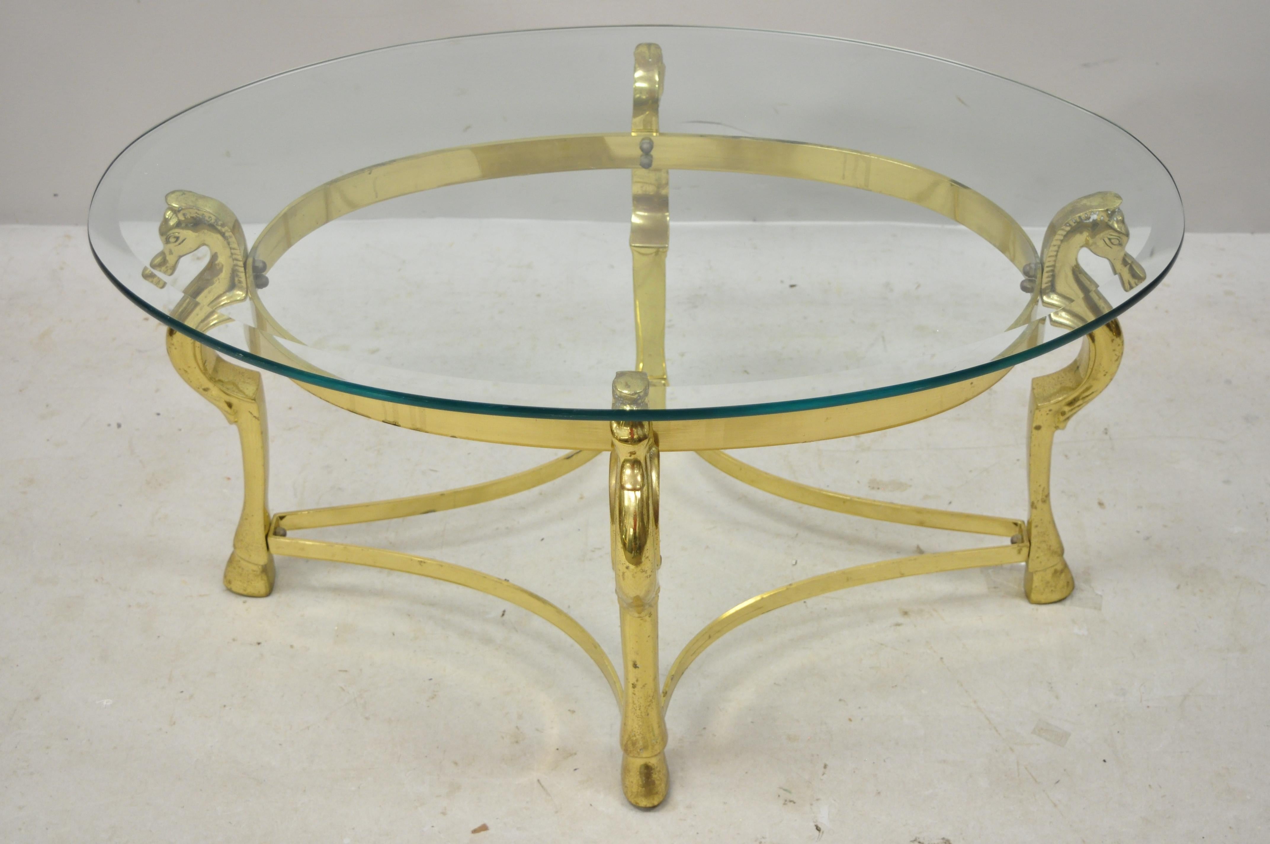 Vintage Italian Hollywood Regency brass seahorse small oval glass top coffee table. Item features a small oval frame, seahorse accents, heavy solid brass construction, original label, oval beveled glass top, great style and form,
circa mid-20th