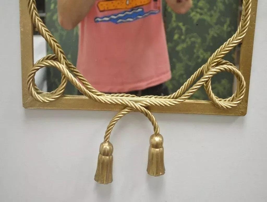 Espejo de pared vintage italiano Hollywood Regency de hierro dorado con borla de cuerda. El artículo tiene la forma de la Gran Regencia de Hollywood, la etiqueta Made in Italy todavía está puesta. Mediados del siglo XX. Medidas: 30