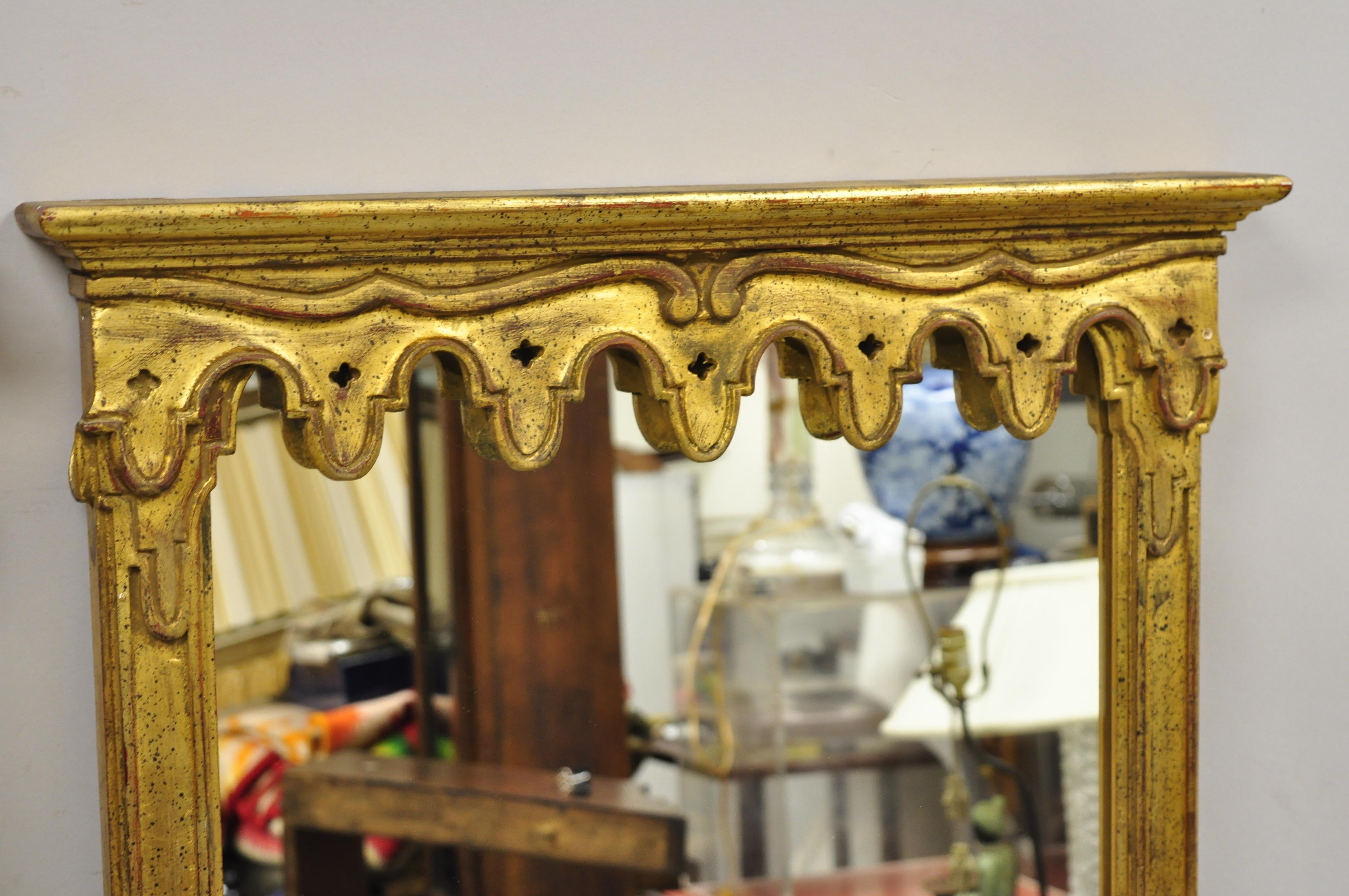 Vintage Italian Hollywood Regency gold giltwood trumeau hall wall mirrors - a pair. Item features carved giltwood frames with drape pediment, distressed finish, nicely carved details, original label, very nice vintage pair, quality Italian
