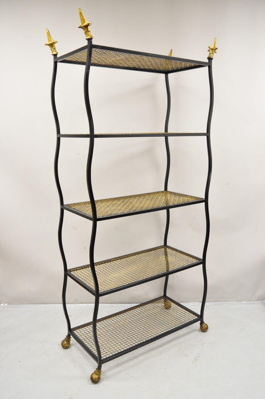 Vintage Italian Hollywood Regency Wrought  Iron Black and Gold Bookshelf Etagere. Item features pointed gold finials, black iron frame, gold iron metal mesh shelves, ball form feet, distressed finish, sleek sculptural form. Circa Mid to Late 20th