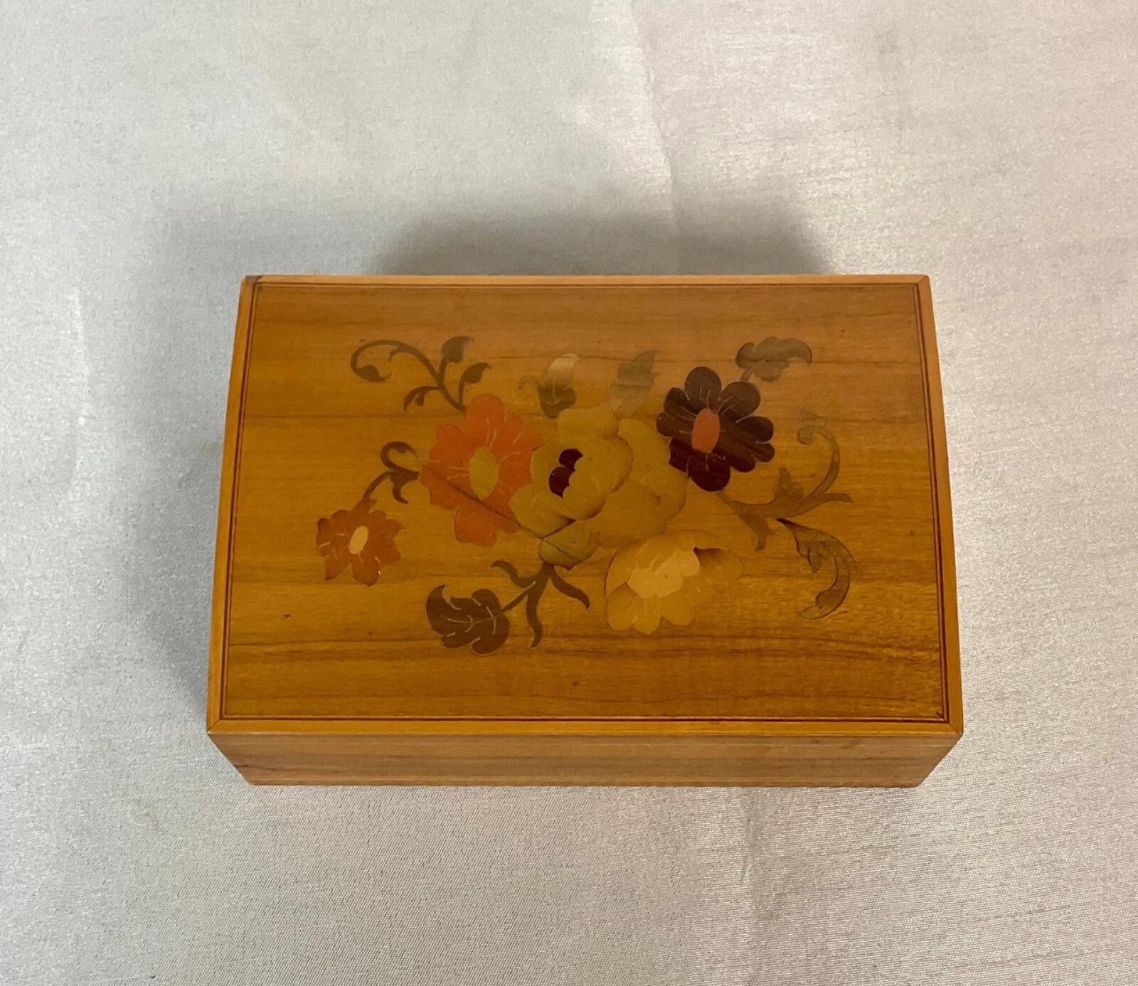Diese schöne Vintage-Holzkiste aus Italien aus dem 20. Jahrhundert ist ein schönes Beispiel für traditionelle Handwerkskunst. Die Schatulle zeigt ein bezauberndes Blumendesign, das sorgfältig mit Holzintarsien hergestellt wurde und verschiedene