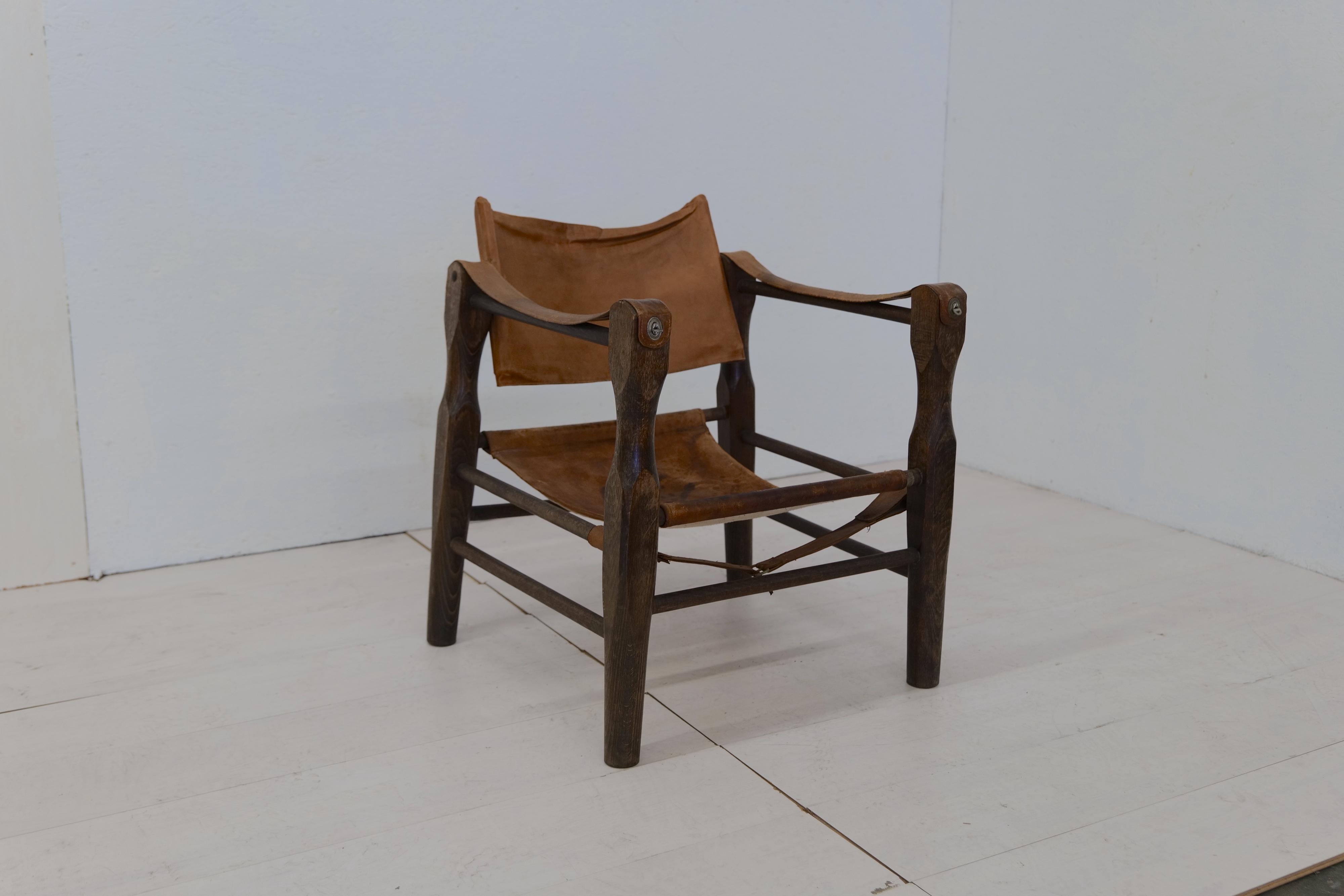 The Vintage Italian Leather and Wood Safari Chair from the 1970s is a distinctive and adventurous piece of furniture. Inspired by the African safari aesthetic, this chair showcases a wooden frame with sleek lines and folding functionality for easy