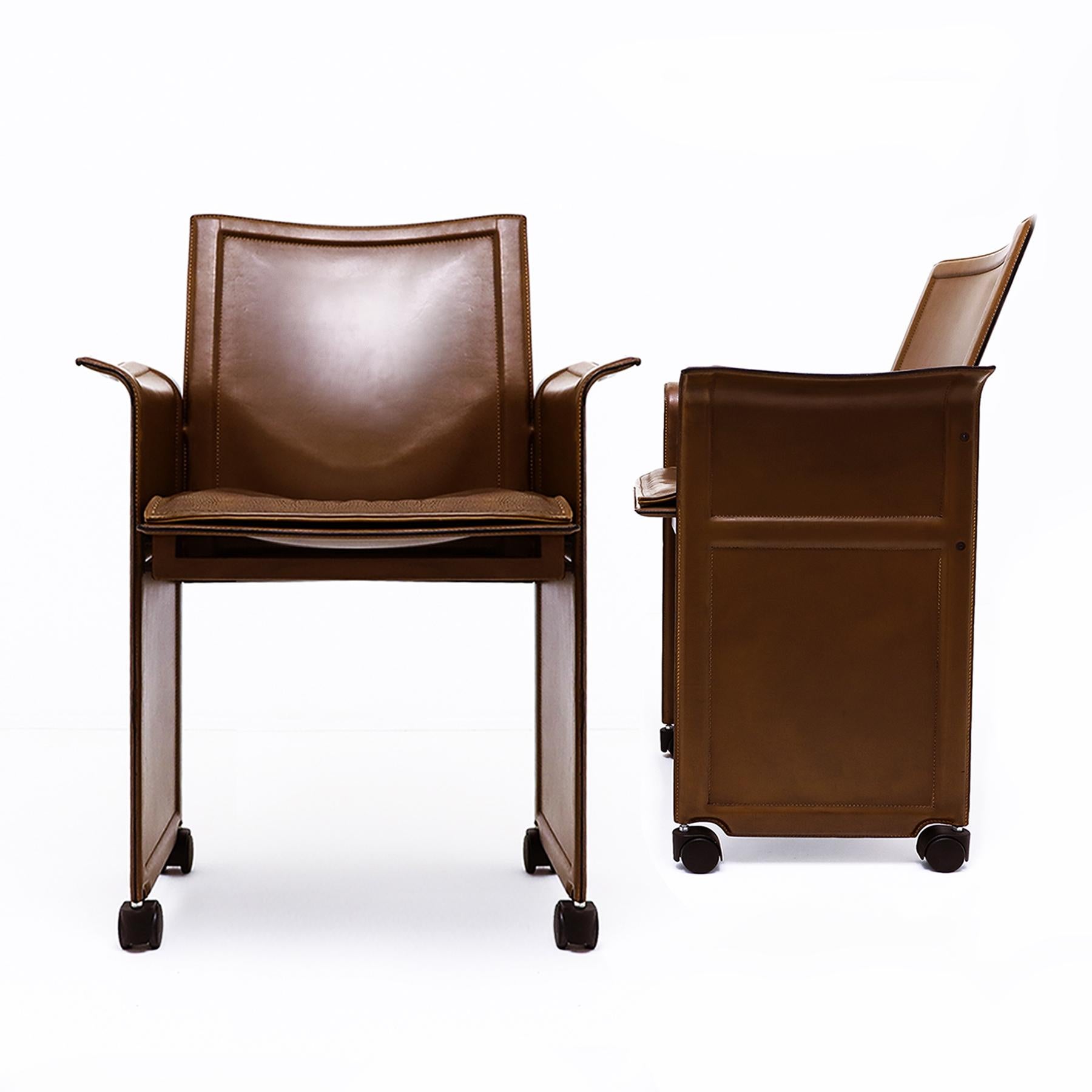 A pair of vintage Italian brown leather Korium armchairs with a steel frame on black castors, designed by Tito Agnoli for Matteo Grassi, 1980s – the price is for both chairs.

This pair of chairs date from the 1980s and were part of series of