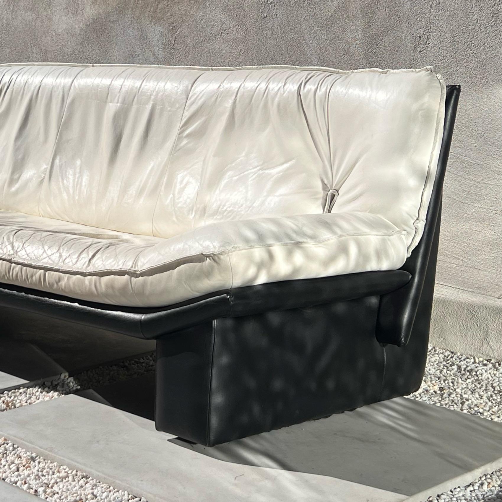 An icon of postmodern design: a Nicoletti Salotti 3seater sofa in white and black leather, made in Italy circa 1980. This design broke from the more organic forms of mid century seating aesthetics, which incorporated streamlined wood and - still,