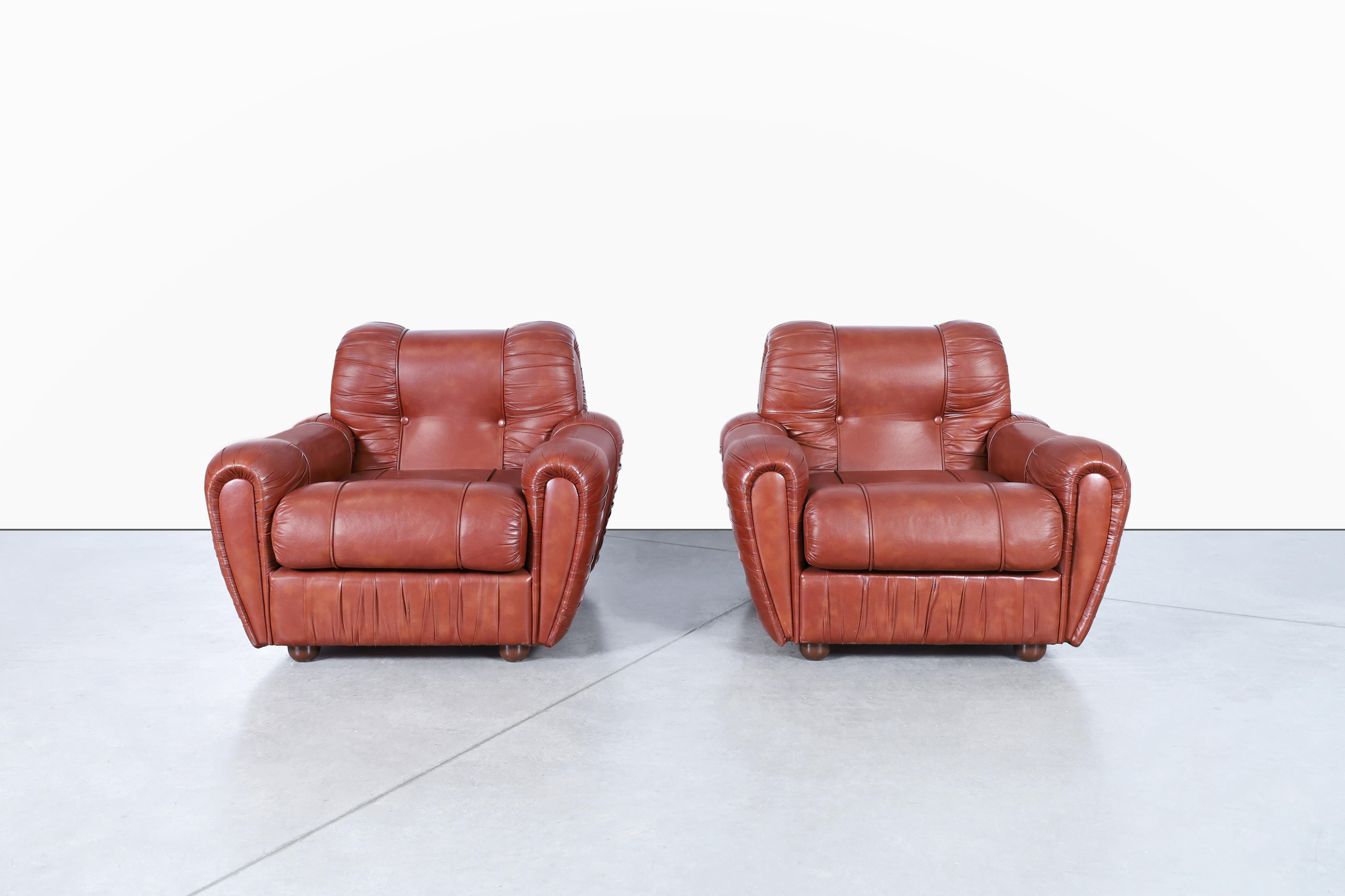 These beautiful vintage Italian leatherette lounge chairs are a true testament to the avant-garde design and exceptional craftsmanship of the 1980s Italian furniture industry. The chairs boast a strikingly welcoming design that is both elegant and