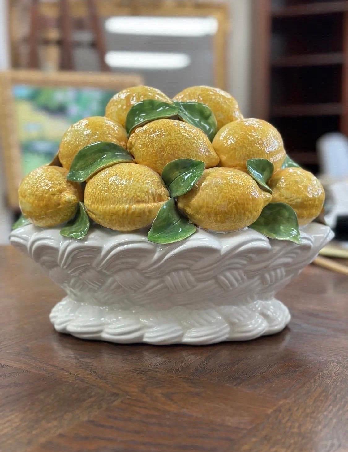 El centro de mesa de cerámica italiana vintage de limones esmaltados es encantador.  Los detalles pintados a mano están bellamente representados, mostrando limones vibrantes y llenos de vida dentro de una cesta de intrincado diseño. El esmalte