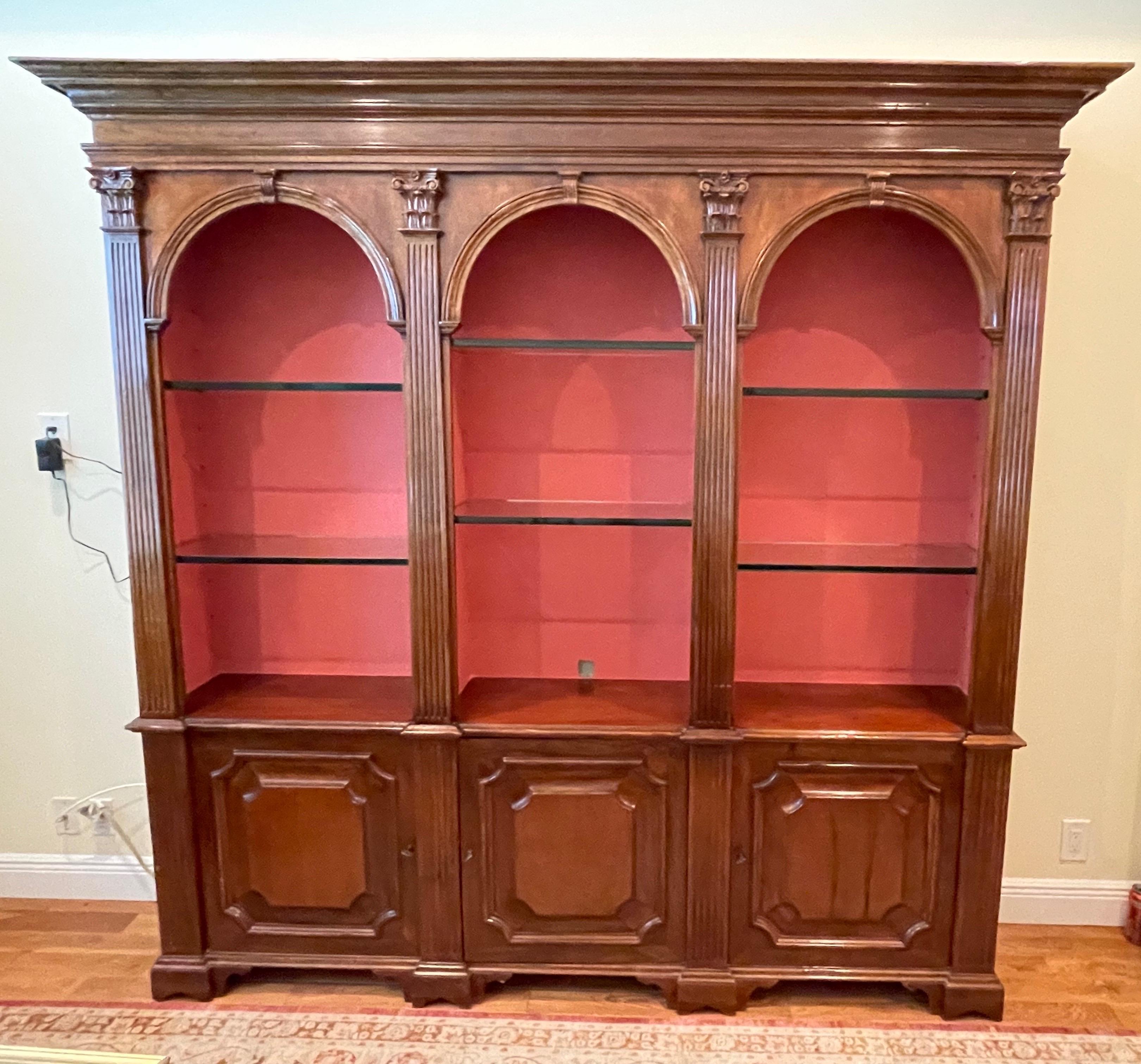 Vintage Italian walnut library cabinet. The top has three compartments with adjustable glass shelves. The bottom has three doors with wood shelves inside for storage.
