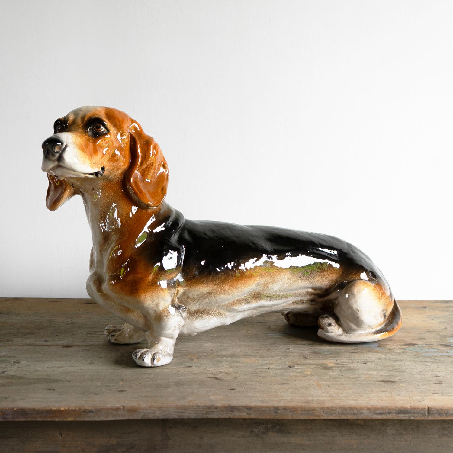 Statua di cane salsiccia di metà secolo. Cagnolino nero, marrone e bianco dal manto piebaldino in ceramica smaltata. Modellato con un'adorabile faccina impertinente! Eccellente qualità, non firmata ma con il timbro 