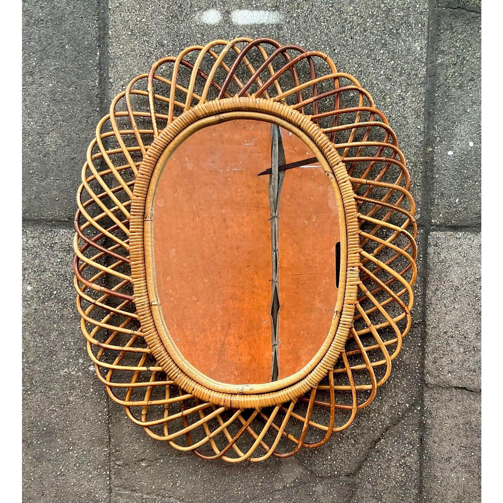 Cattura l'essenza del modernismo italiano del Mid-Century con questo splendido specchio vintage in rattan. Disegnato secondo il ricercato stile di Franco Albini, questo pezzo è una masterclass di design organico e artigianato. Lo specchio ha una