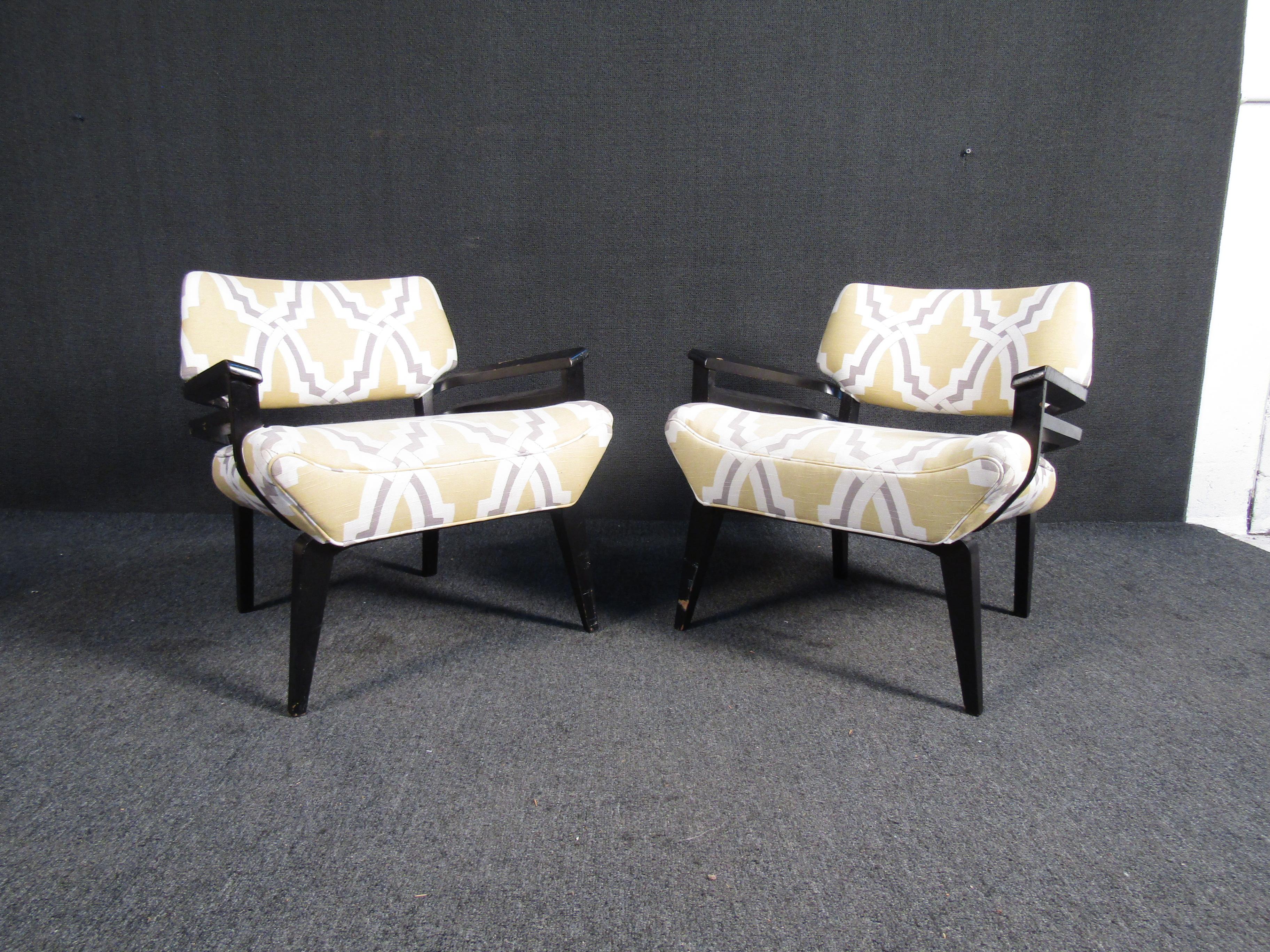 This elegant pair of vintage modern Italian lounge chairs feature thick padded seating and a black lacquered frame. A sleek and comfortable low sitting design that has splayed tapered legs. This stylish Italian modern pair of lounge chairs are sure