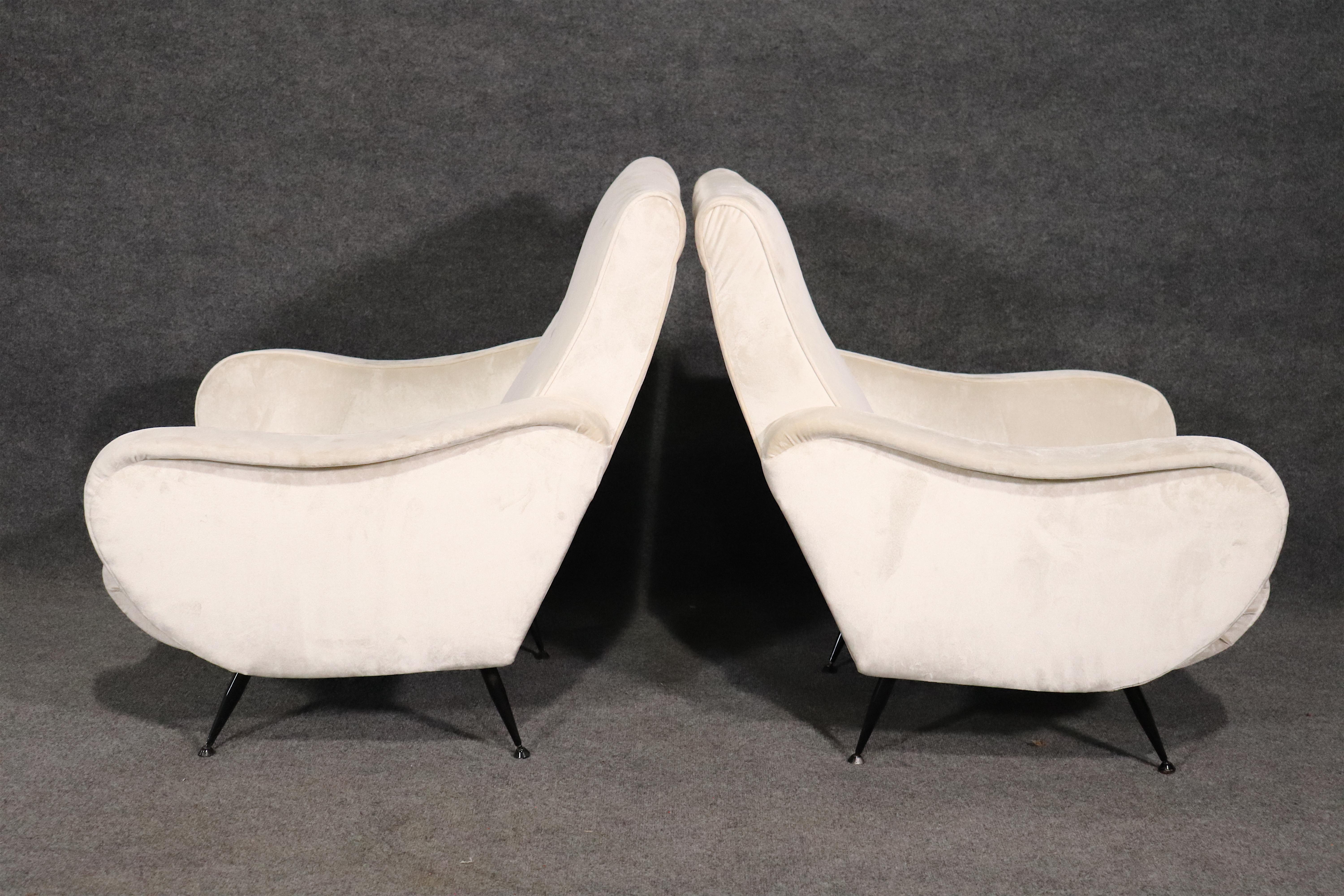 Vintage modern Italian designed lounge chairs with flowing arms and buttoned back rest. Set on black metal legs.
Please confirm location.
  