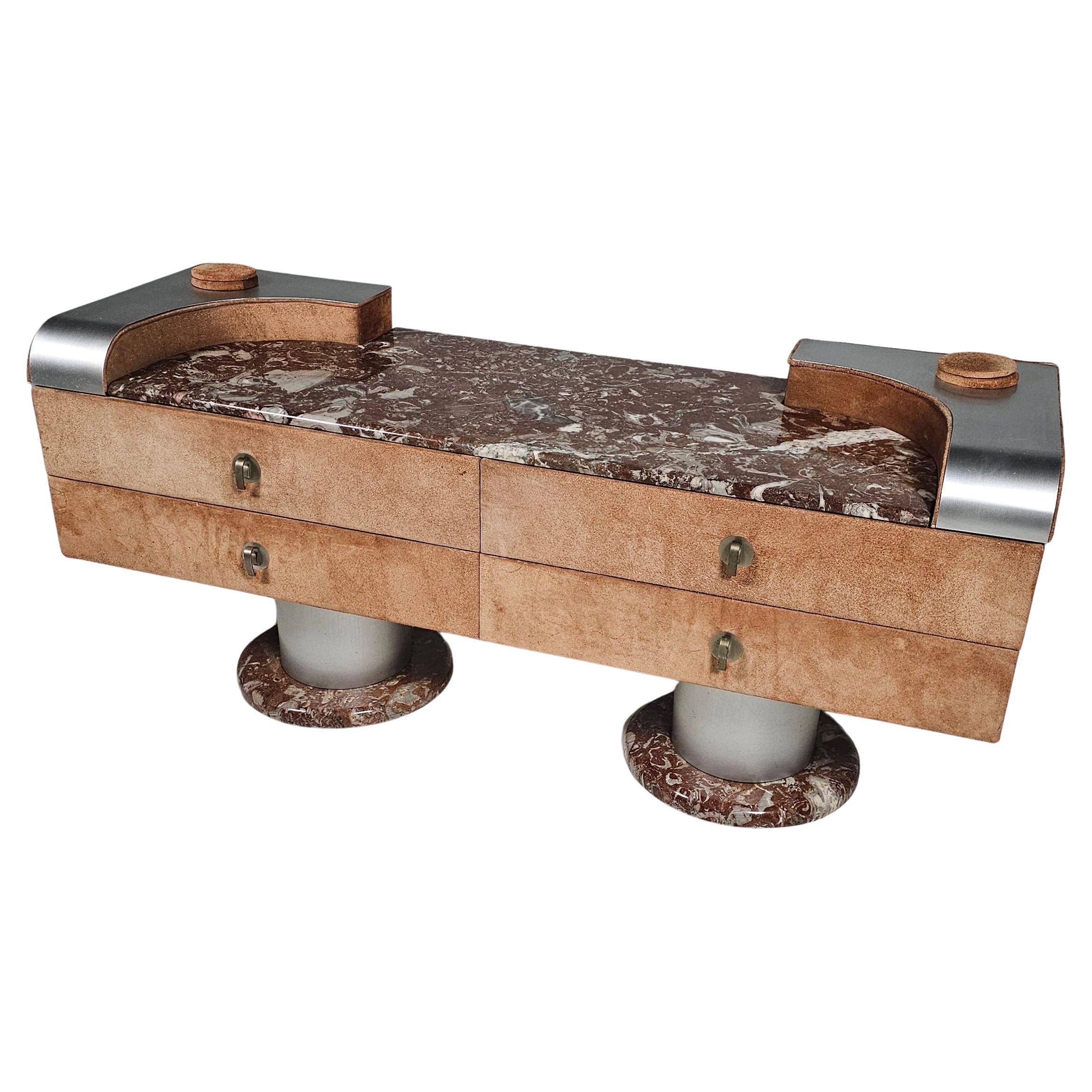 Beautiful and rare vintage lowboard. A striking blend of elegance and bold materials.  Crafted in Italy, it features a luxurious red marble top and feet, aluminum legs, and soft suede panels.  A statement piece in both form and function.

Its