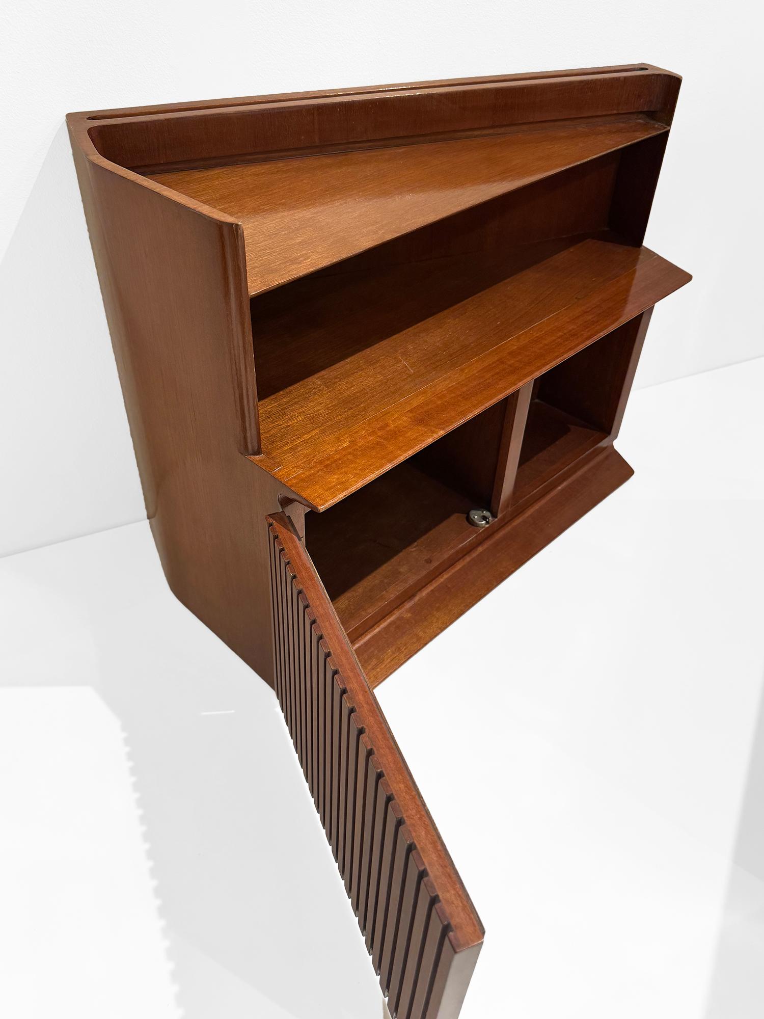 A pair of mahogany wood wall mounted bed side tables. These unique side tables feature a trapezoidal shape with an open niches, glass lined shelves, as well as extra enclosed storage. Beautiful Italian mid century design make these floating side