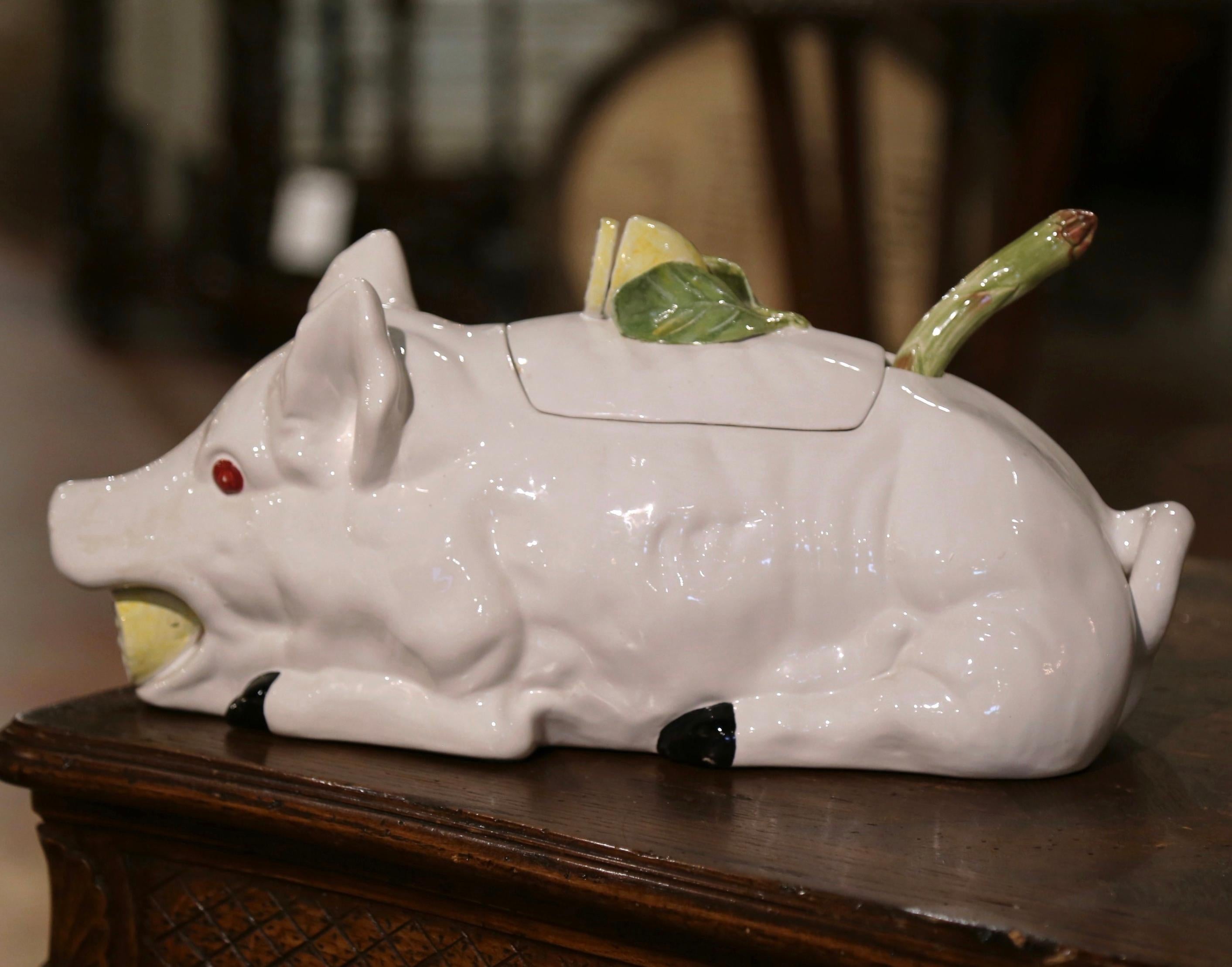 Decorate a dining table with this cheerful Majolica centerpiece. Crafted in Italy circa 1980, the decorative tureen is shaped as a pig resting, his mouth opened holding a lemon. The removable lid, embellished with leaf and lemon decor; when opens,