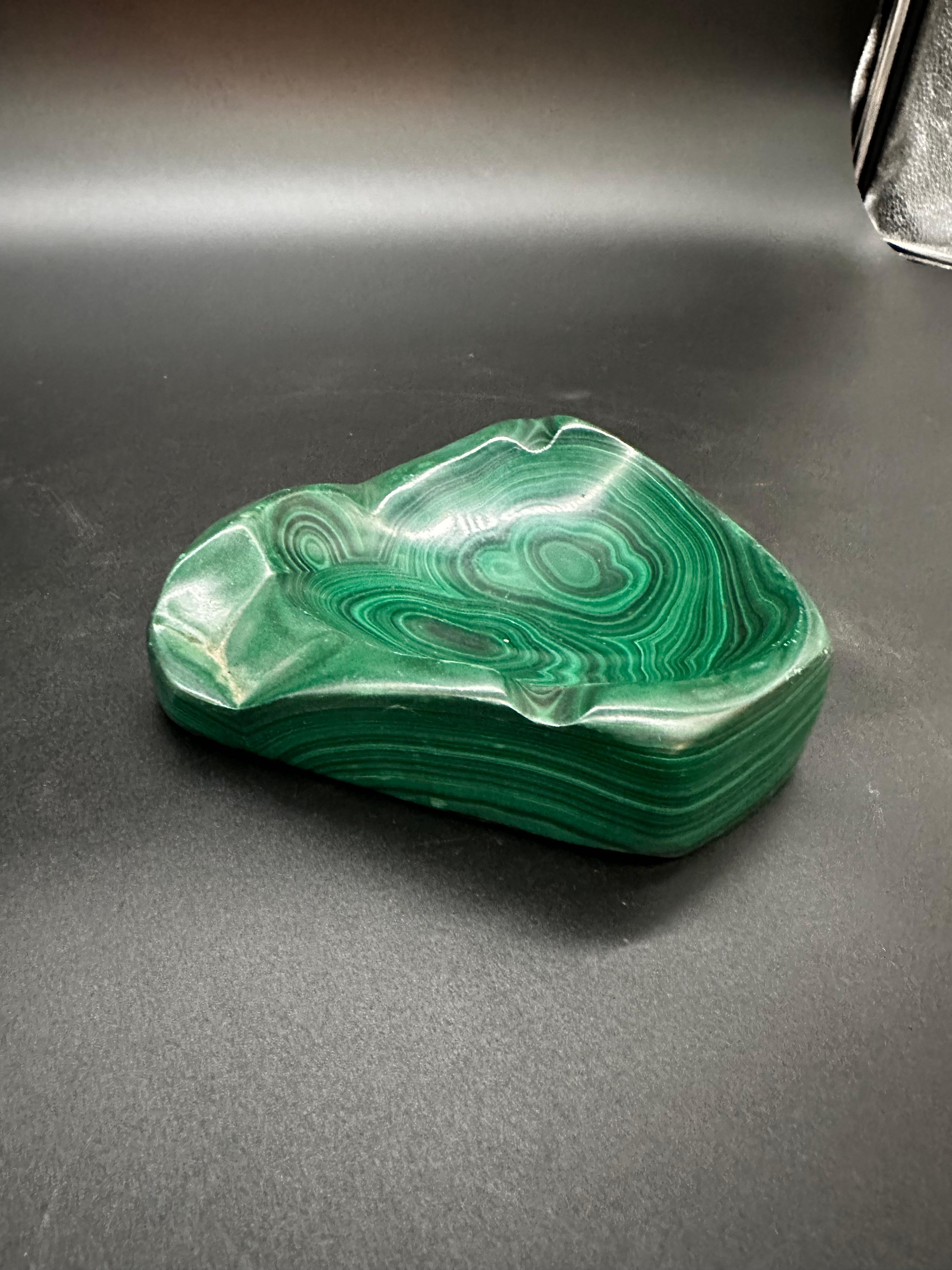A vintage Italian Malachite ashtray from the 1960s is a small, decorative dish crafted from malachite stone in Italy during the 1960s. It likely features vibrant green hues characteristic of malachite, with a sleek and elegant design typical of the