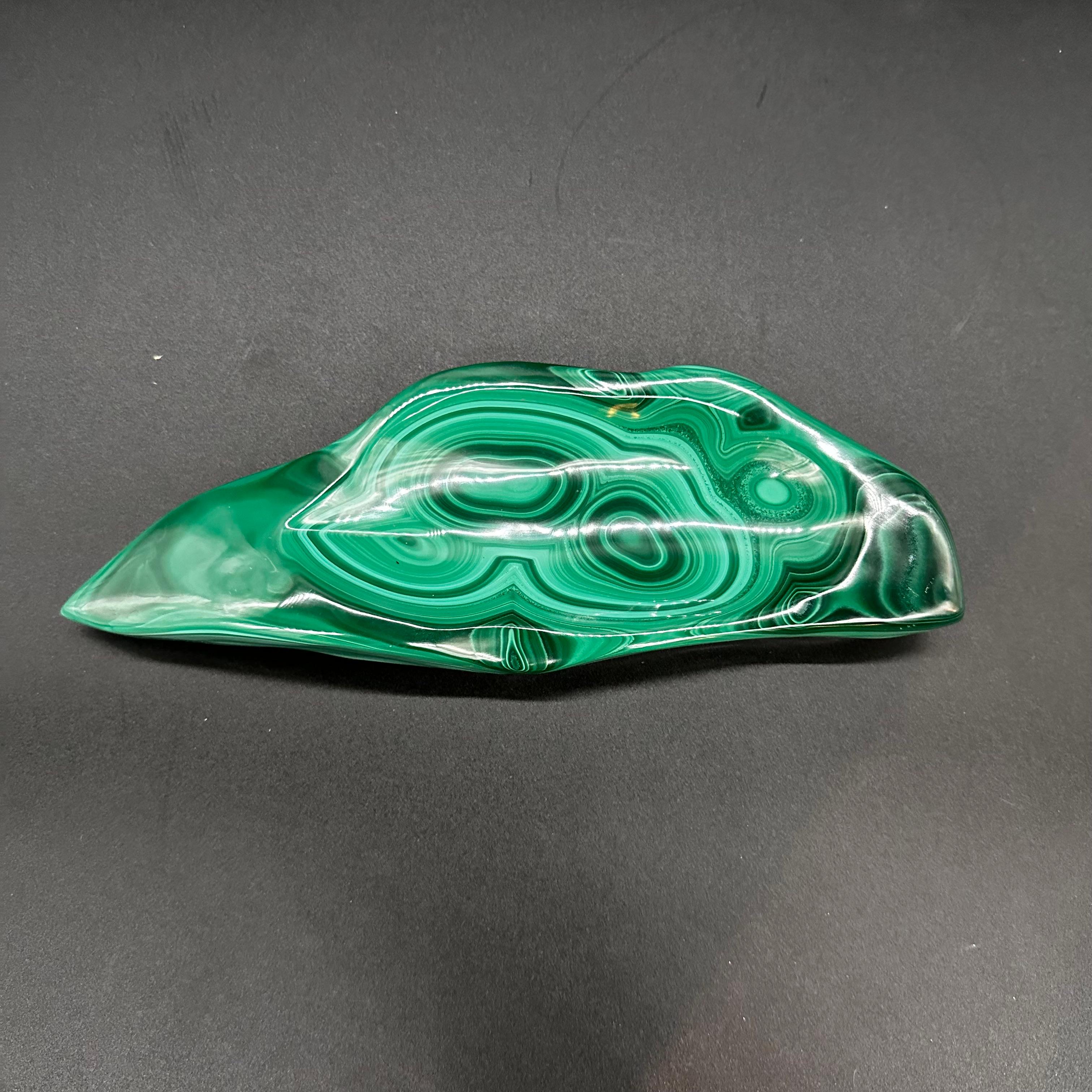 The Vintage Italian Malachite Ashtray from the 1960s is a stunning example of mid-century design and craftsmanship. Made from genuine malachite stone, prized for its rich green hues and intricate patterns, this ashtray exudes luxury and
