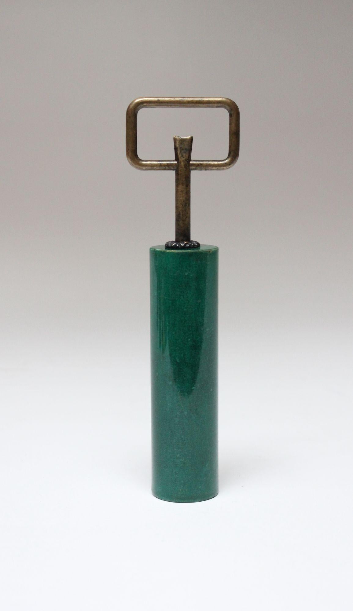 Aldo Tura bottle opener/cap lifter composed of a dyed malachite green goatskin wrapped handle with rectangular brass opener (ca. 1950s, Italy).
Unusual example with the rectangular top (most commonly, the cap lifters are round).
Rich patina to the