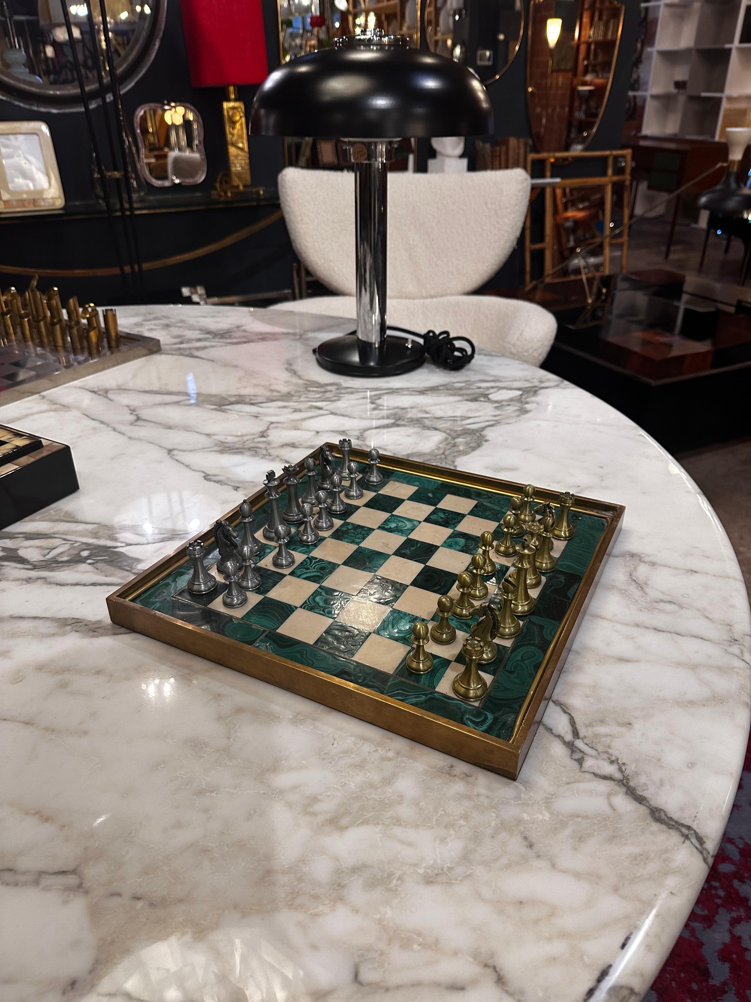 Le grand jeu d'échecs italien vintage en malachite des années 1960 est un chef-d'œuvre d'artisanat captivant. L'échiquier, en malachite luxueuse, arbore une riche teinte verte, tandis que les pièces d'échecs en métal qui l'accompagnent ajoutent une