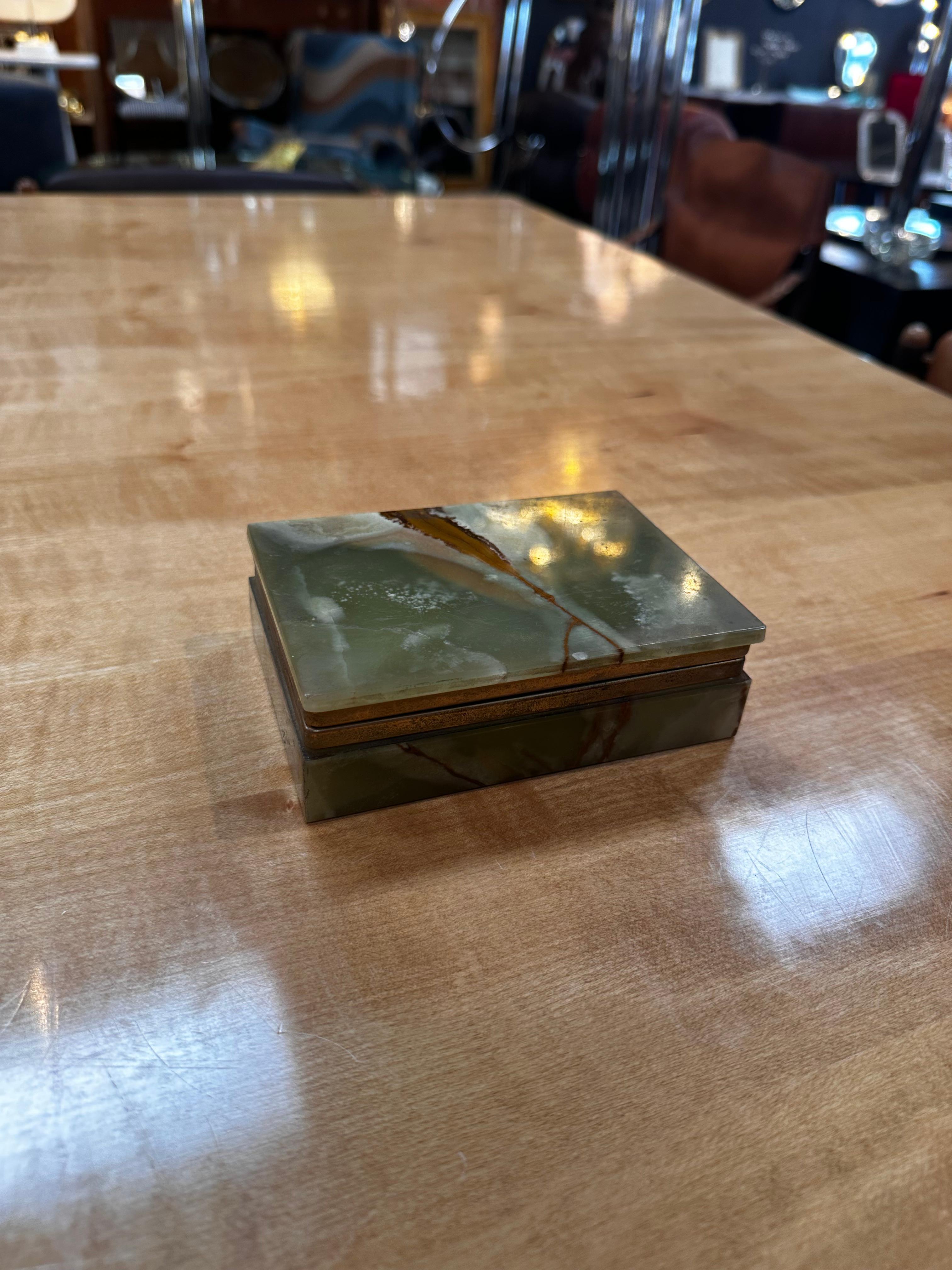 A Vintage Italian Marble and Brass Decorative Box from the 1970s is a sophisticated piece of functional art. This box seamlessly combines luxurious marble with brass accents, showcasing the elegant design aesthetics of 1970s Italian decor.

