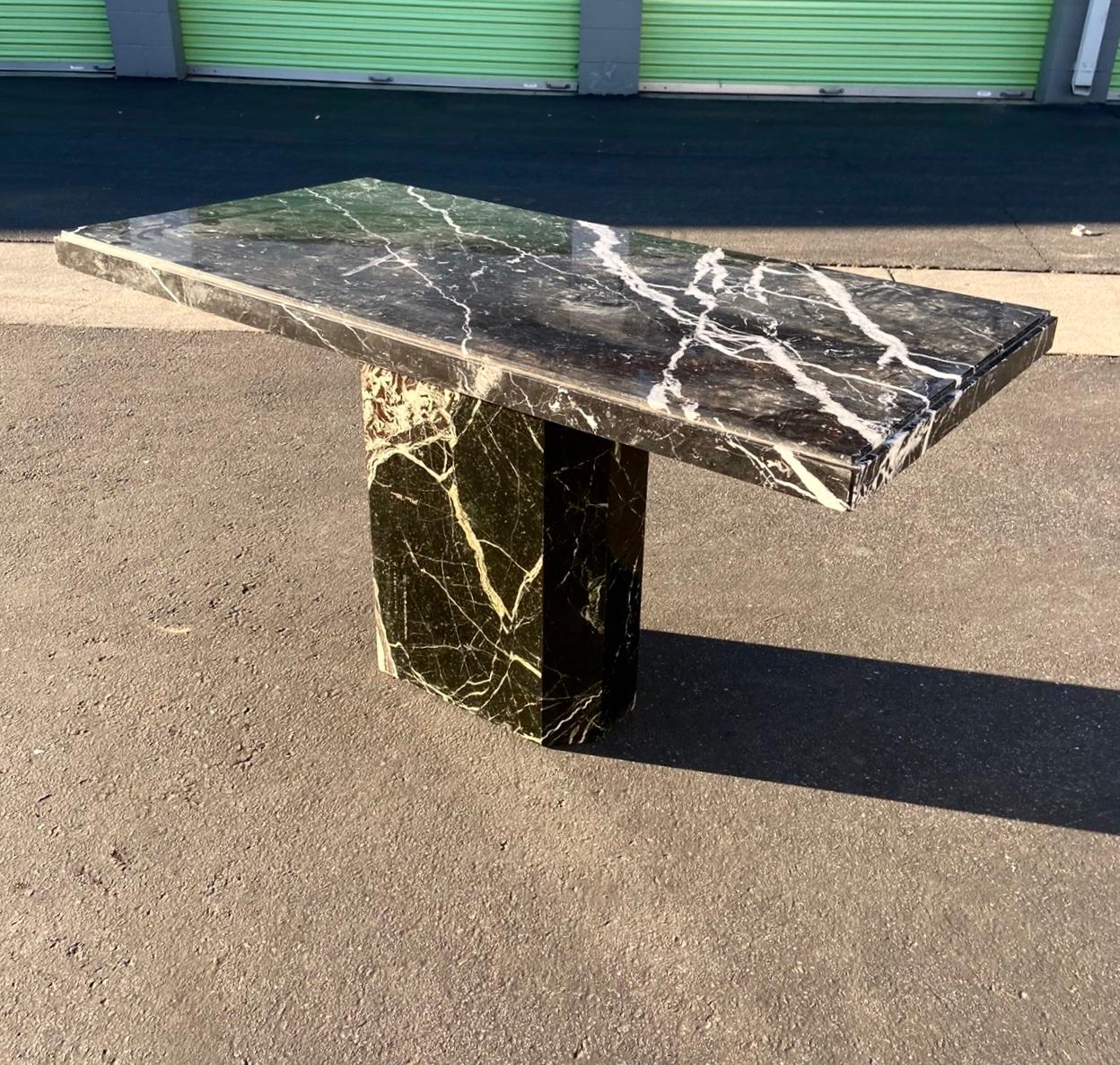 A vintage Italian marble dining table with pedestal base, late 1960s or early 70s. On the smaller side -  a rare size for one of these postmodern Italian stone tables - so please note measurements. Tones of black and burgundy with exquisite ivory