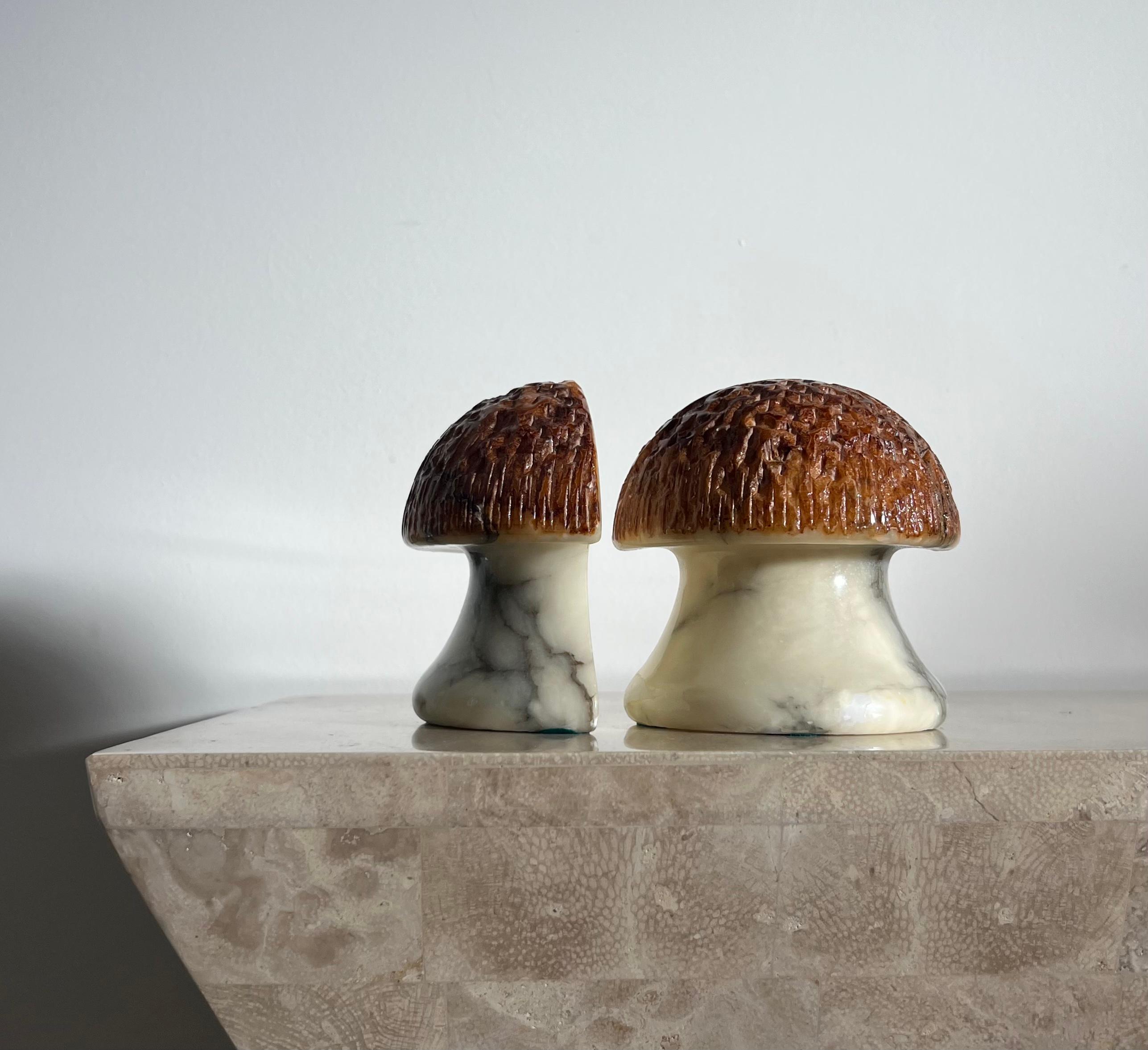 A pair of vintage Italian marble mushroom bookends, late 1960s. Hand-carved in Italy. Bases are cream colored with ash veining, while caps are a rich toffee hue and are textured. A wonderful gift for any fan of the psychedelic or any lover of the