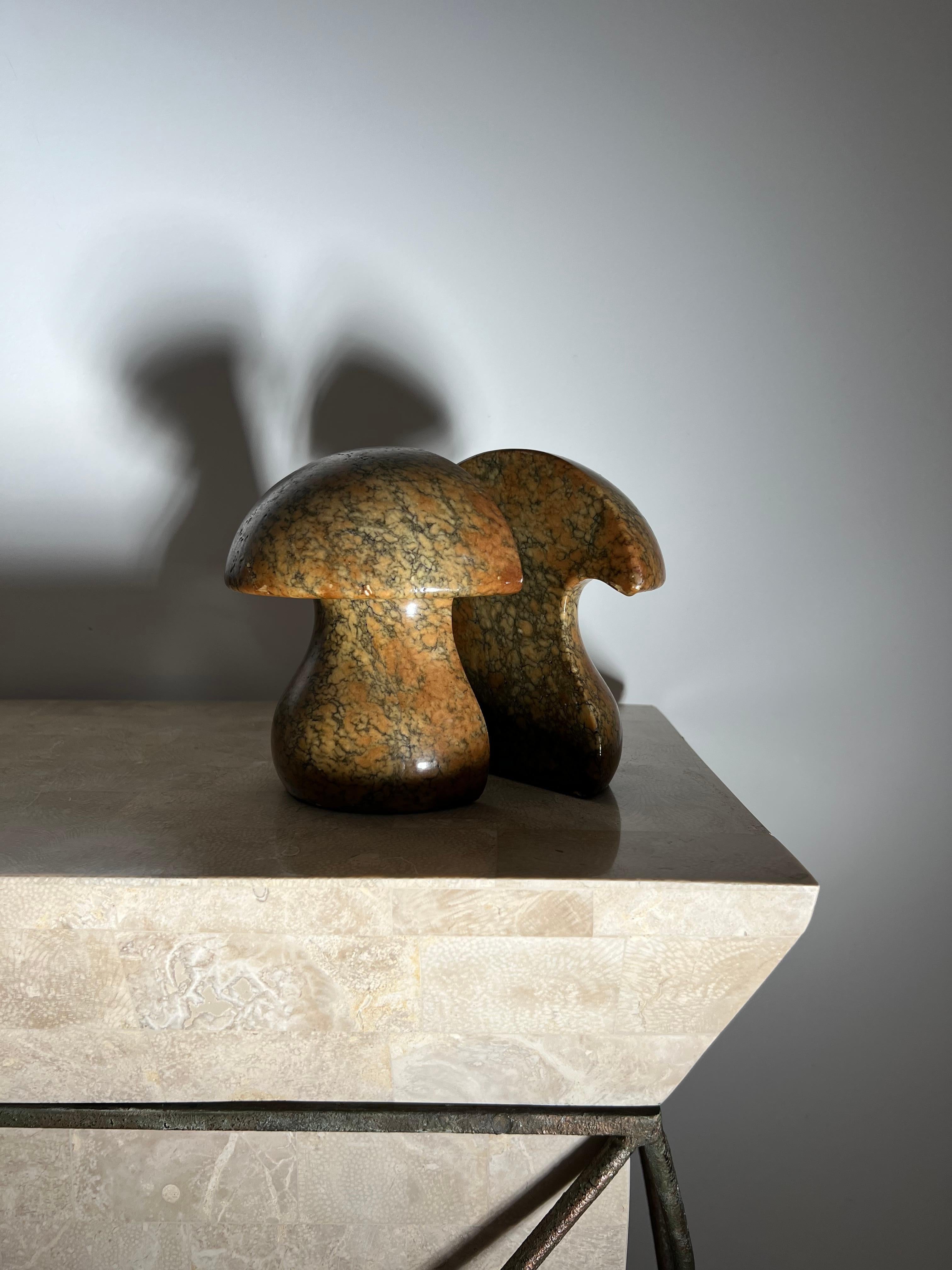 A pair of vintage Italian mid century modern mushroom marble bookends, circa 1960s. Hand-carved in Italy and featuring tones of caramel, pewter, and cognac. Felted bases. Some minor scuffs here and there but no significant damage or