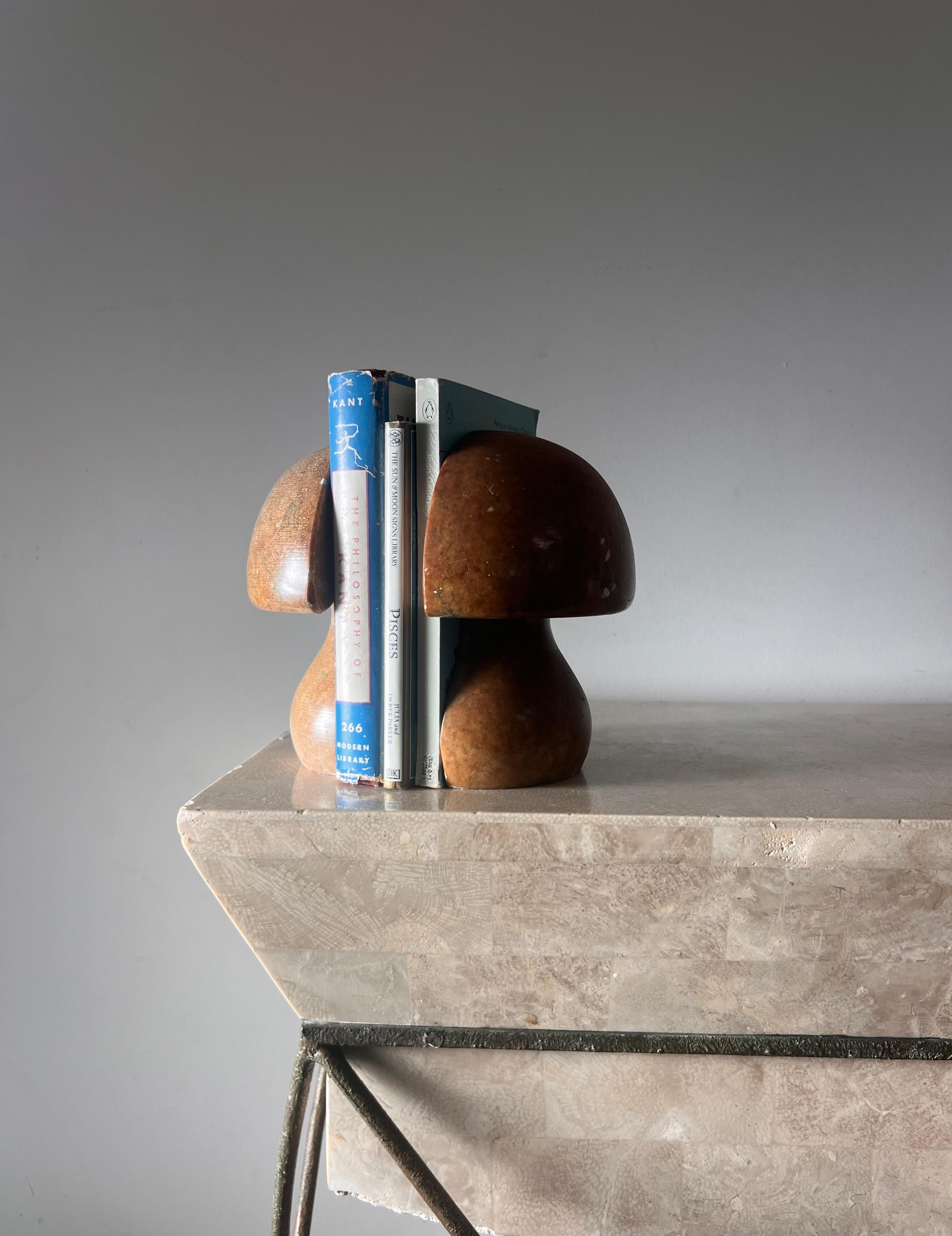 A pair of mid century modern vintage Italian hand-carved alabaster mushroom bookends, circa 1960. Tones of caramel, hay, and pewter, and featuring bombastic chunky curves. Some scratches and nicks but no glaring flaws or losses. Pick up in central