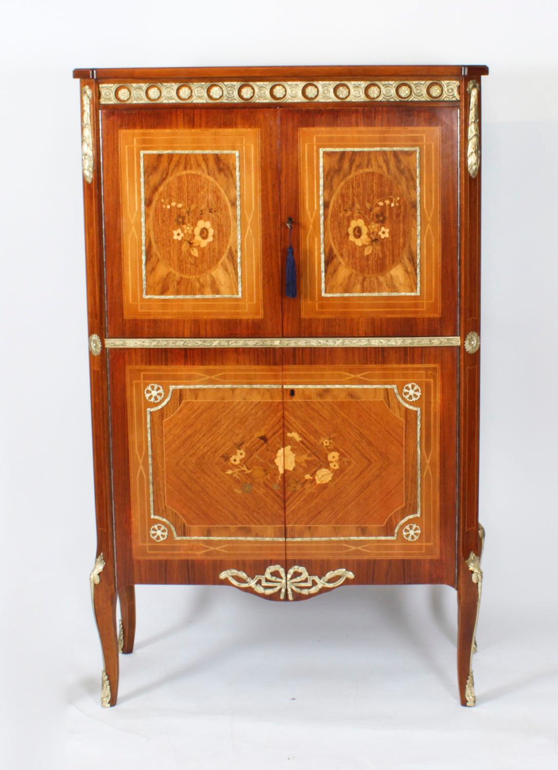 Si tratta di uno stupendo mobile vintage di metà secolo intarsiato e ormeggiato in radica di noce, datato Circa 1950.

La coppia di ante con intarsio centrale a cartiglio floreale in legno di raso e parquet con motivo a stella che si estende si apre