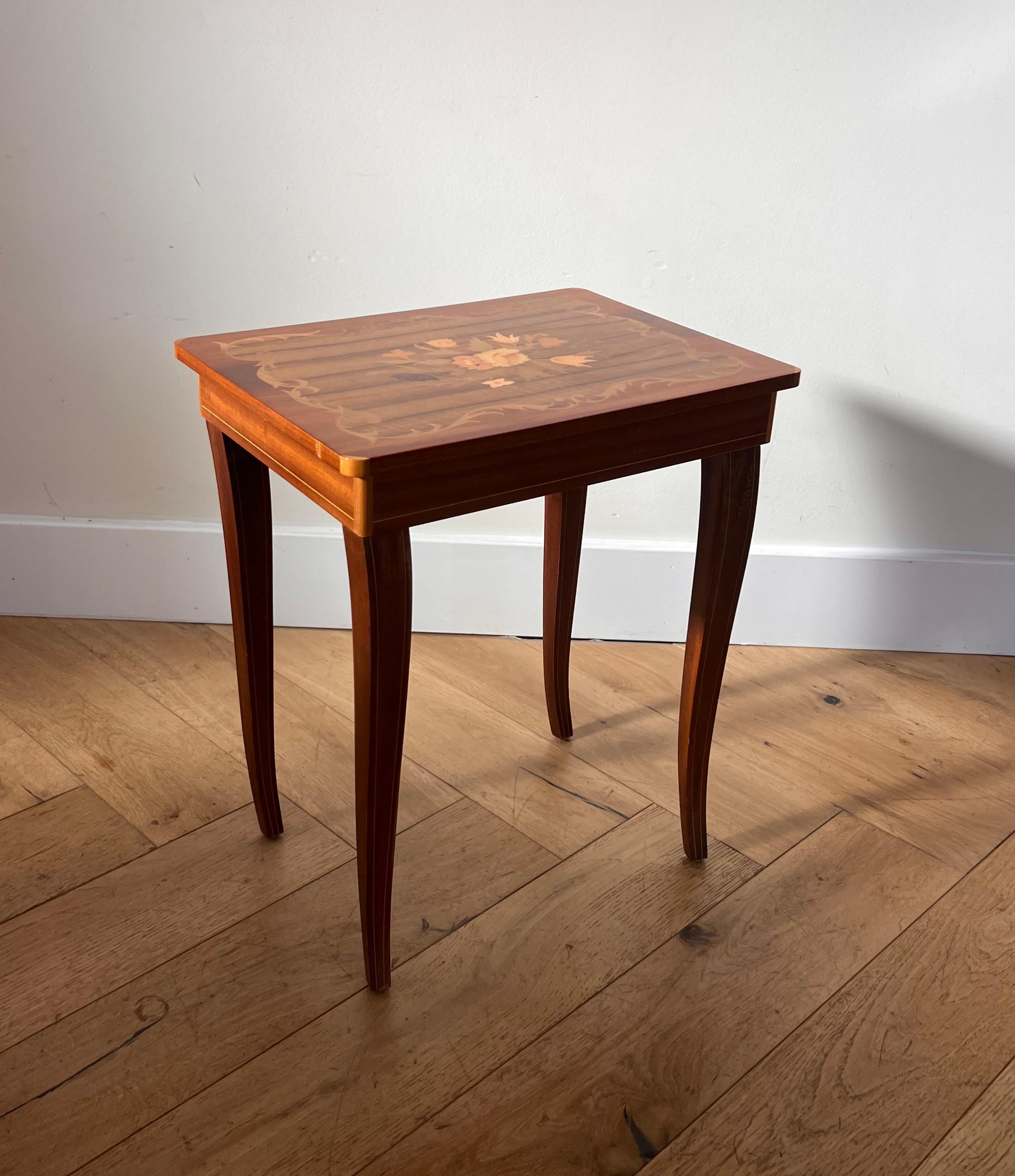 A delightful little Italian marquetry side table which opens to reveal a whimsical melody from a hidden music-box. Made in Italy circa late 1950s, this piece recalls baroque and rococo sensibilities. Good condition with minor signs of age.