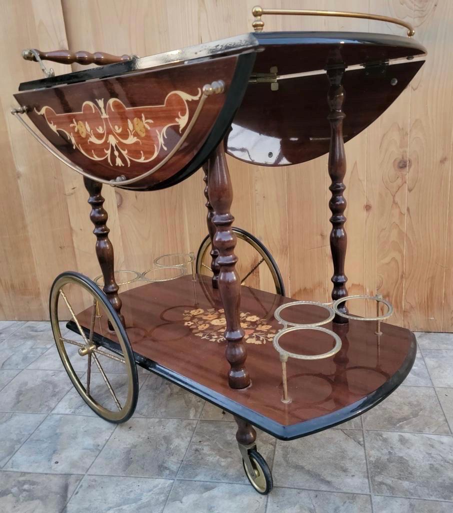 Vintage Italian Marquetry Two Tier drop-leaf dessert/bar cart trolley

Impress your guests with this spectacular Hollywood Regency serving cart. Italian marquetry inlaid design with high gloss finish. Two tiers with six places for wine or liquor