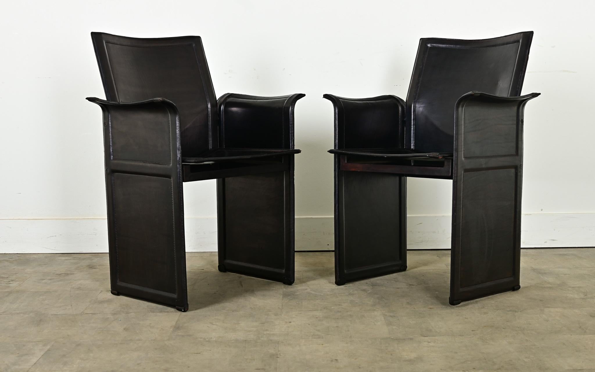 Pair of vintage Italian black leather armchairs by designer Tito Agnoli for the brand Matteo Grassi, circa 1979. Named the “Korium”, the chair design features an all-steel frame wrapped in high-quality stitched saddle leather. Constructed with