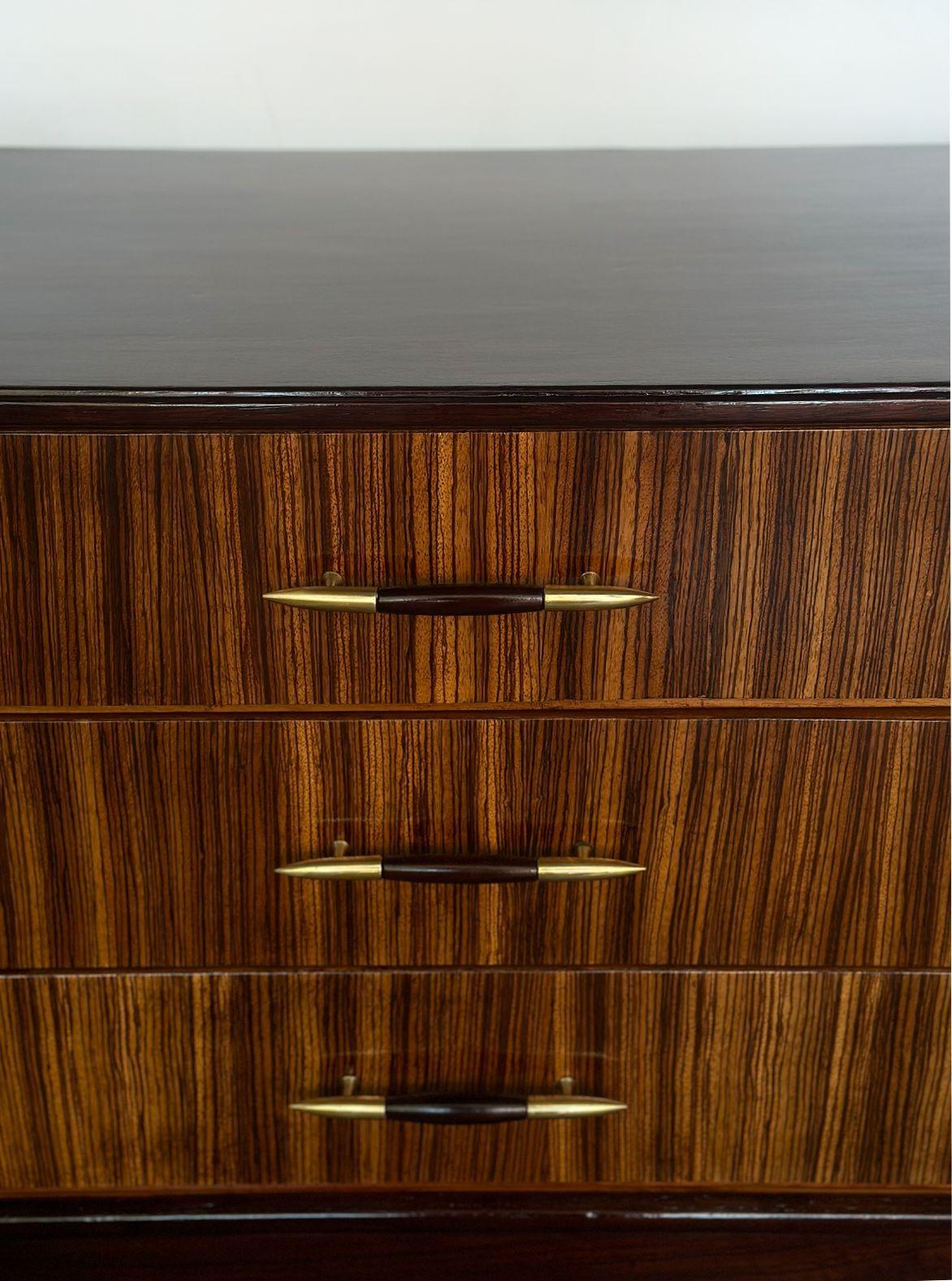 Vintage mid-century dresser made in Italy in the 1950s; made with European walnut, zebra wood and fine brass details which are integrated into the drawer handles and gracefully tapered legs. The piece has been newly refinished.
The dresser offers