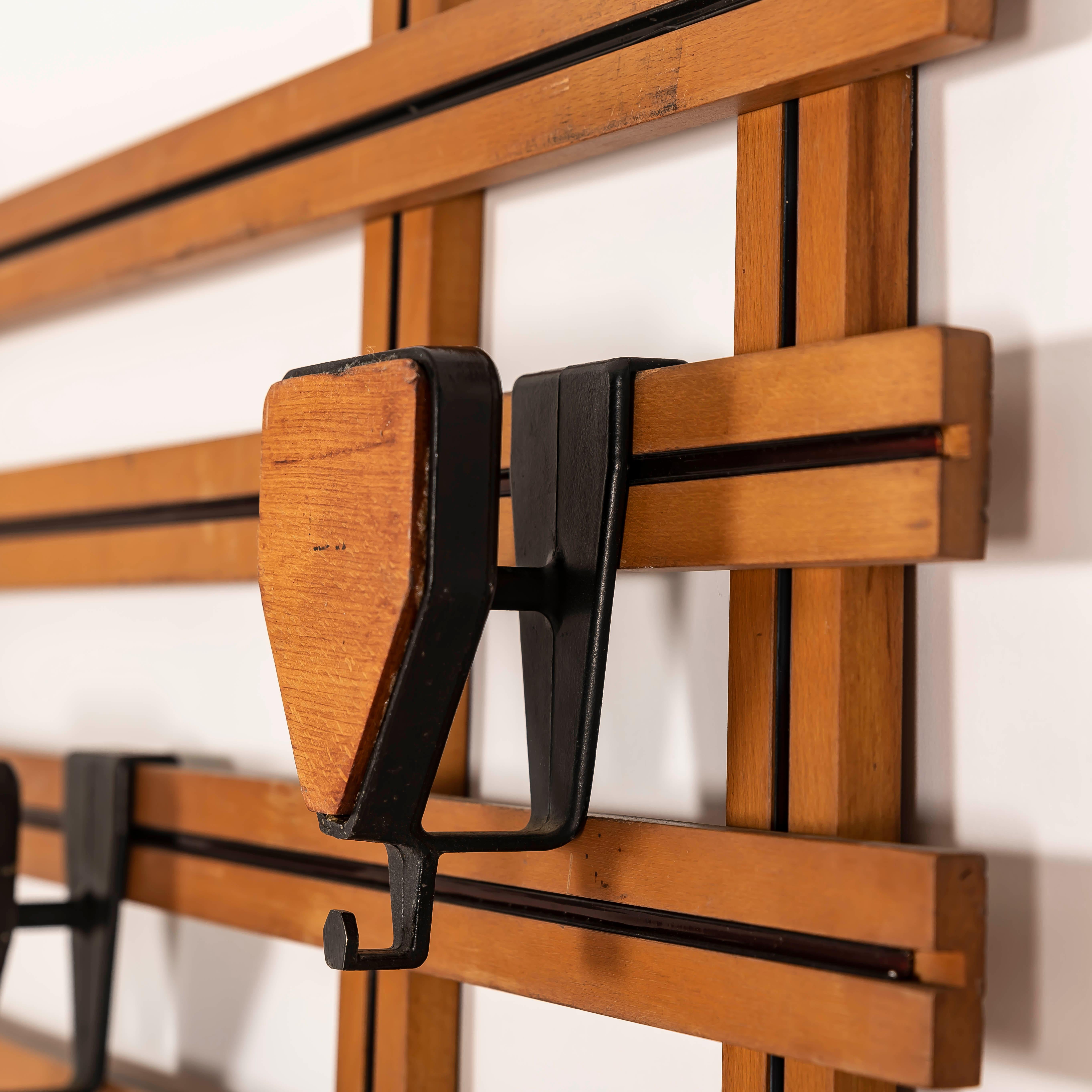 Mit dieser seltenen Wandgarderobe aus den 1950er Jahren verleihen Sie Ihrem Eingangsbereich oder Wohnbereich einen Hauch italienischer Eleganz aus der Jahrhundertmitte. Dieses skulpturale Stück aus warmem Holz mit markanten schwarzen linearen