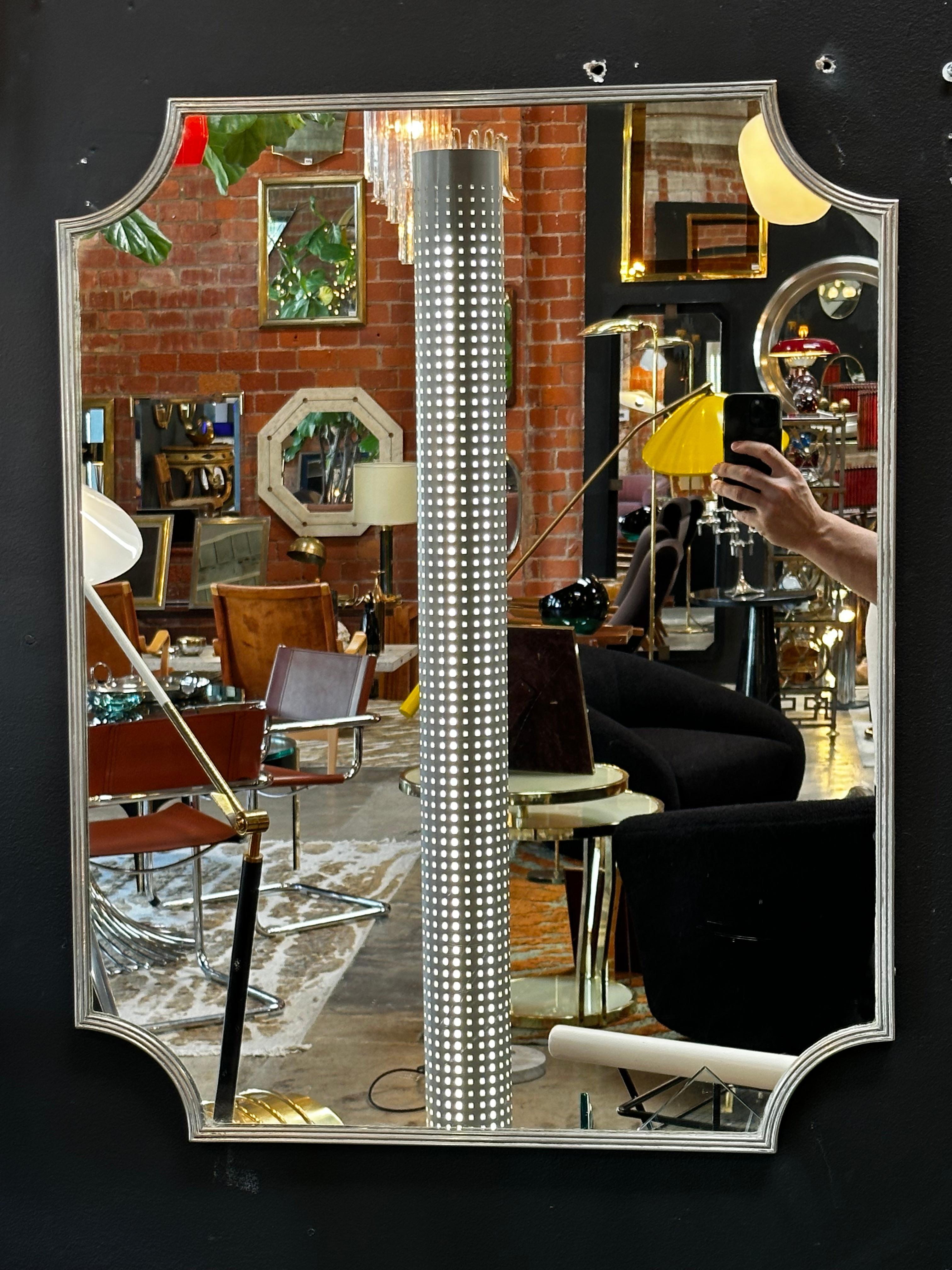 Vintage Italian sculptural wall mirror with a chrome frame and original patina.