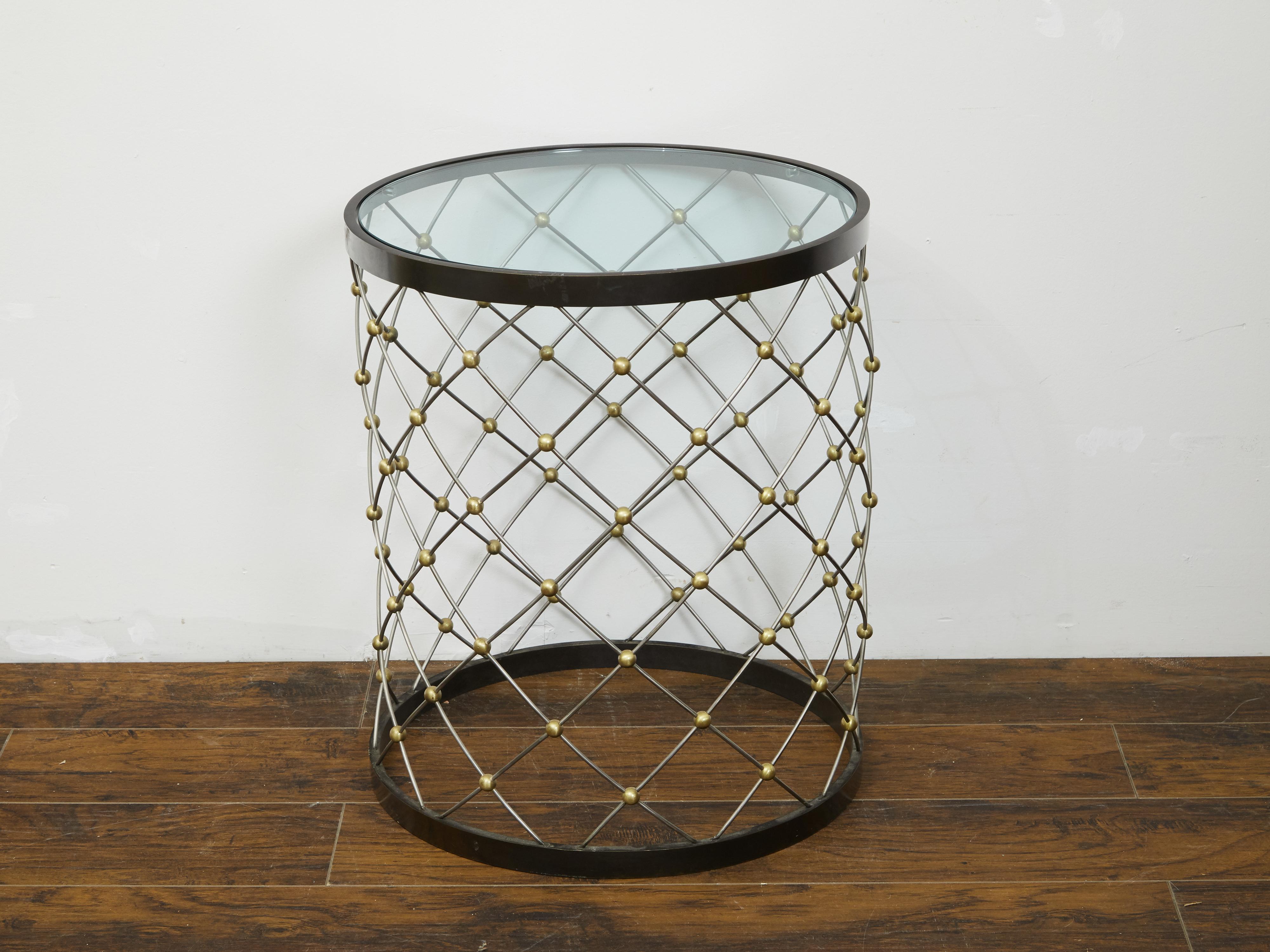 A vintage Italian bronze drum side table from the mid 20th century, with wire style structure and glass top. Created in Italy during the midcentury period, this drum table features a circular glass top resting on a wire-style base accented with