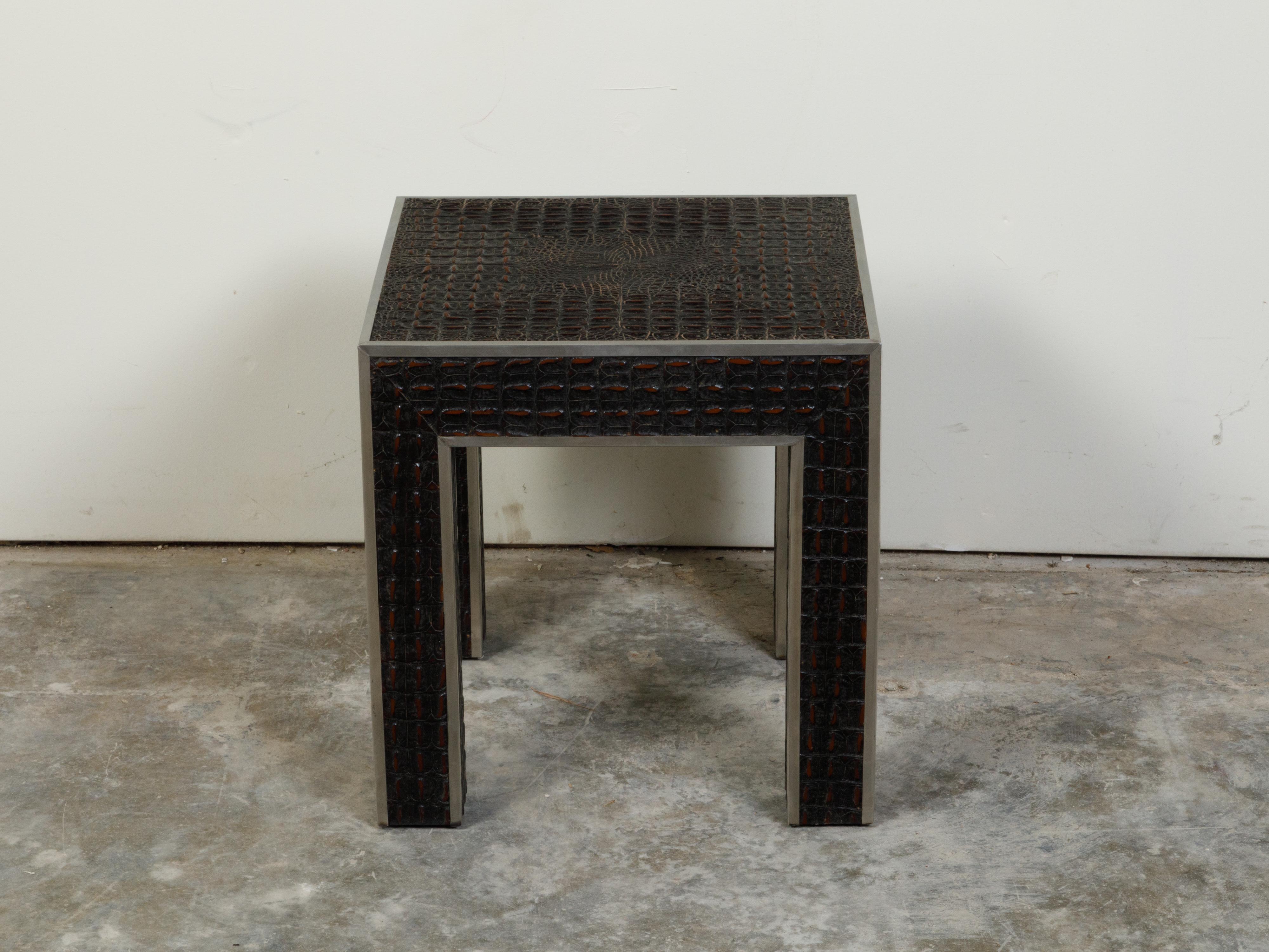 An Italian vintage faux alligator side table from the mid 20th century with metal accents. Created in Italy during the midcentury period, this side table captures our attention with its clean lines perfectly accented by a faux alligator finish.