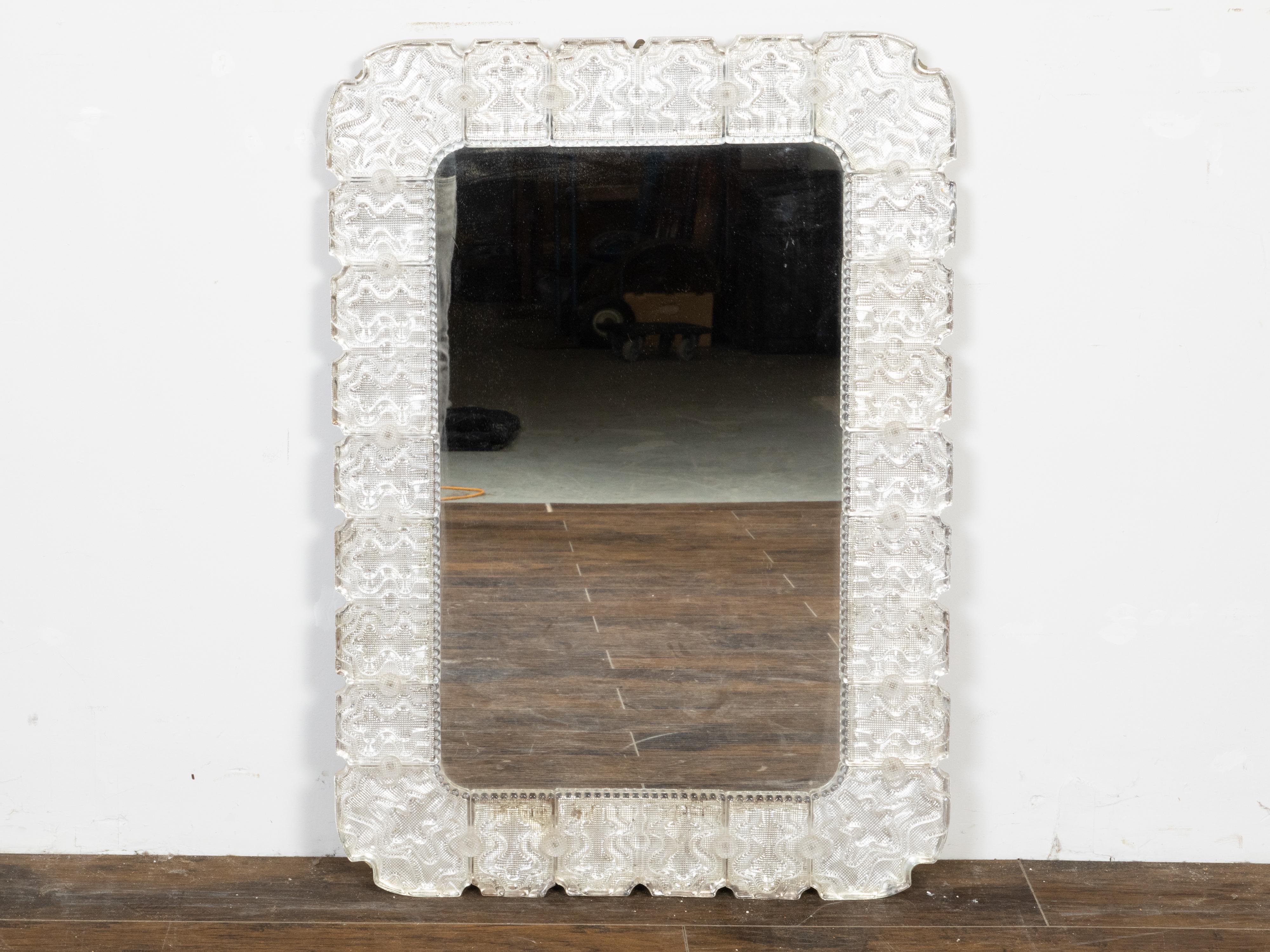 A vintage Italian Venetian glass mirror from the mid 20th century, with shaped motifs. Created in Italy during the Midcentury period, this wall mirror captures our immediate attention with its elegant silhouette and beautifully Venetian glass. Made