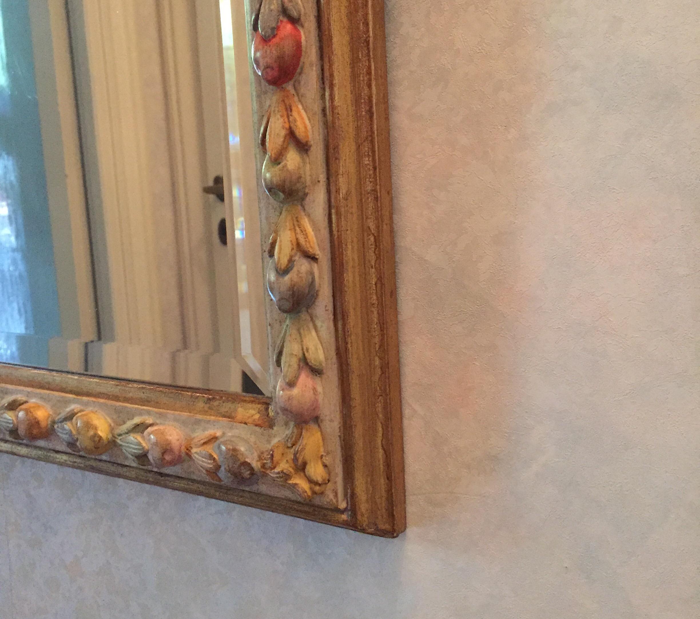 Italian mirror by Florentine manufacture Chelini with a Della Robbia style fruit carving decoration with polychrome soft color painting.
Italian manufacture dating back to, circa 1980.
In good condition, wear consistent with age and use.

It is