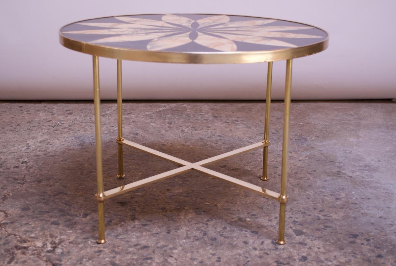Italian modern round side / occasional table having a laminate top with flower decoration raised on brass legs united by an X-stretcher, circa 1950s. Charming piece, reminiscent of designs by Fornasetti, but unattributed.
The coloring and texture of