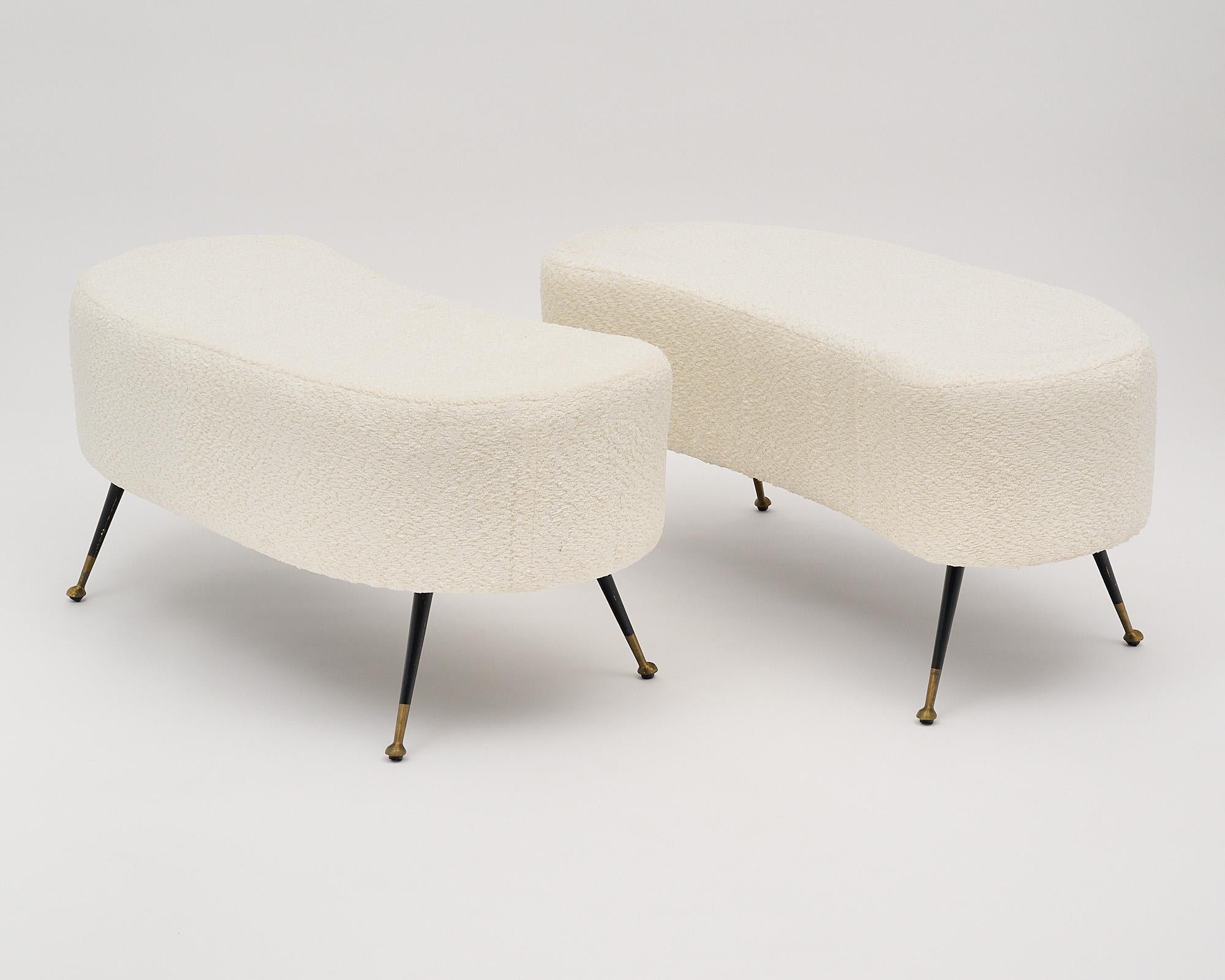 Italian pair of vintage benches with flaring black lacquered legs and solid brass-capped feet. We love their unique and quirky “bean-like” shape, and their quintessential Italian mid-century vibe. They have been newly upholstered in a white boucle